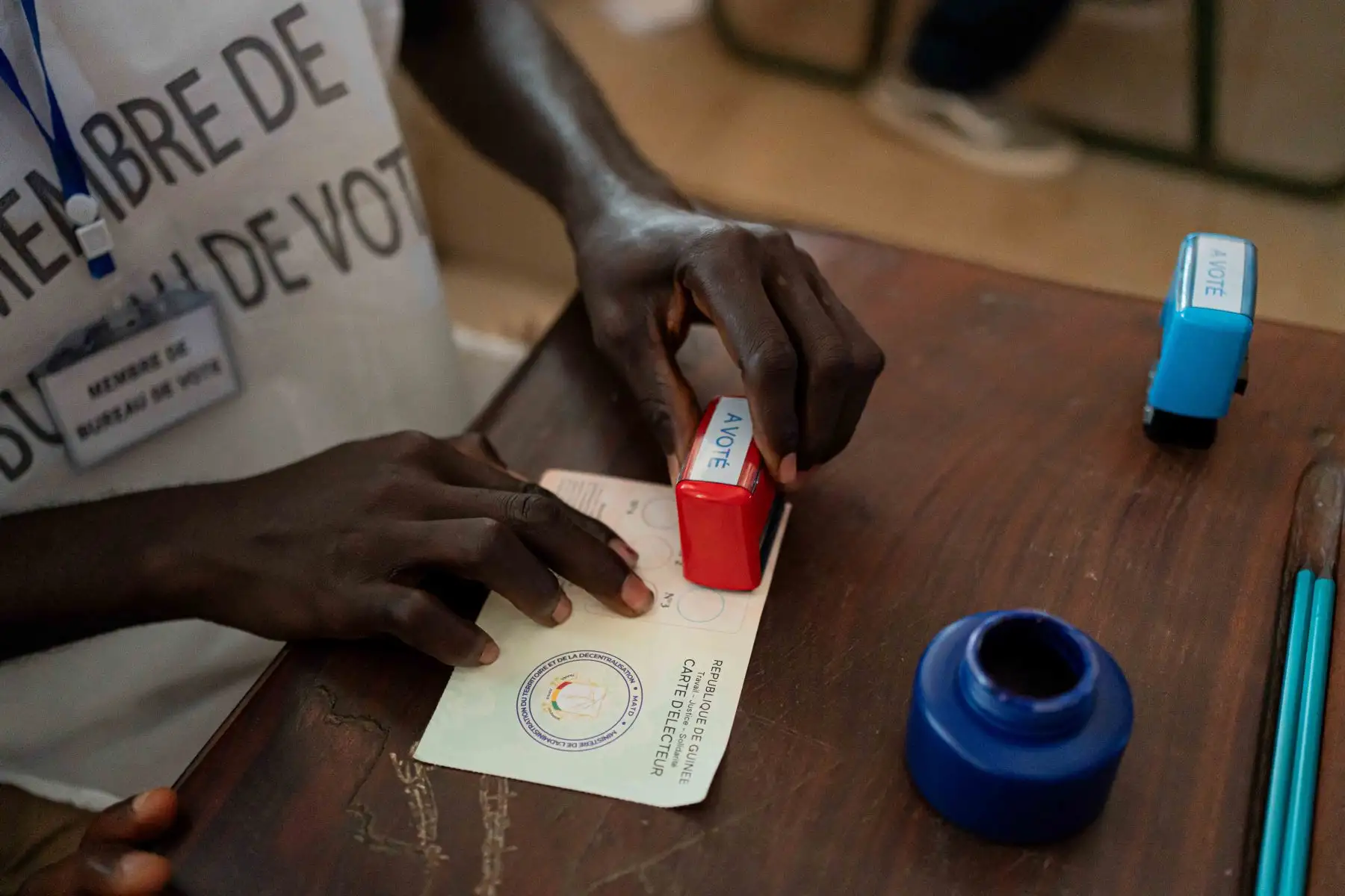 Un funcionario de la Dirección General de Elecciones de Guinea sella una tarjeta en el colegio electoral del Centro Housseine en Conakry, mientras el país entero vota en el referéndum constitucional. Cuatro años después de la toma del poder por los militares, los guineanos finalmente votan sobre un nuevo proyecto de constitución que allanaría el camino para las elecciones. Foto: AFP