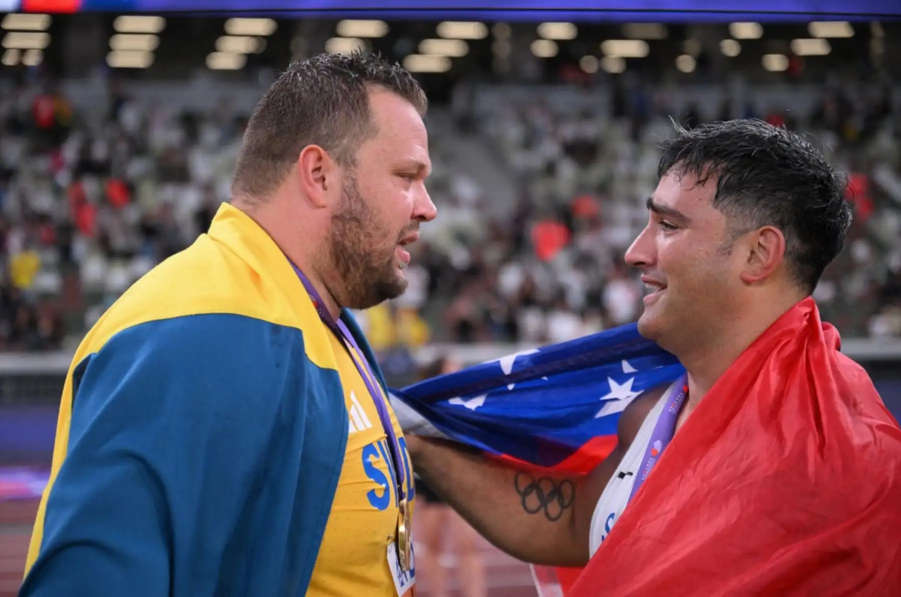 El atleta ganador de Suecia, Daniel Stahl, y el atleta samoano Alex Rose (tercero) celebran después de la final de lanzamiento de disco masculino durante el Campeonato Mundial de Atletismo en Tokio el 21 de septiembre de 2025. Foto: AFP