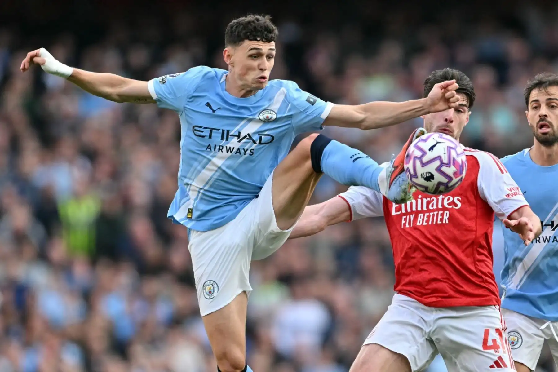 El mediocampista inglés del Manchester City, Phil Foden, compite con el mediocampista inglés del Arsenal, Declan Rice, durante el partido de fútbol de la Premier League inglesa entre el Arsenal y el Manchester City en el Emirates Stadium en Londres el 21 de septiembre de 2025. Foto: AFP