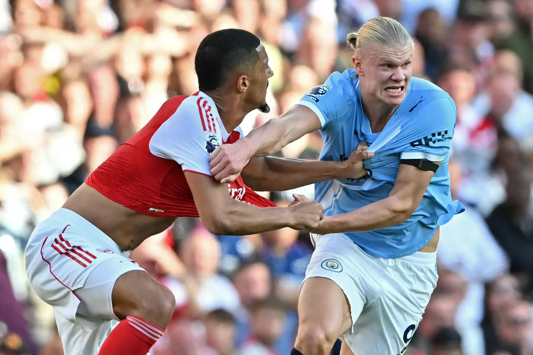 El defensor francés del Arsenal, William Saliba, lucha por el balón con el delantero noruego del Manchester City, Erling Haaland, durante el partido de la Premier League inglesa entre el Arsenal y el Manchester City en el Emirates Stadium en Londres el 21 de septiembre de 2025. Foto: AFP