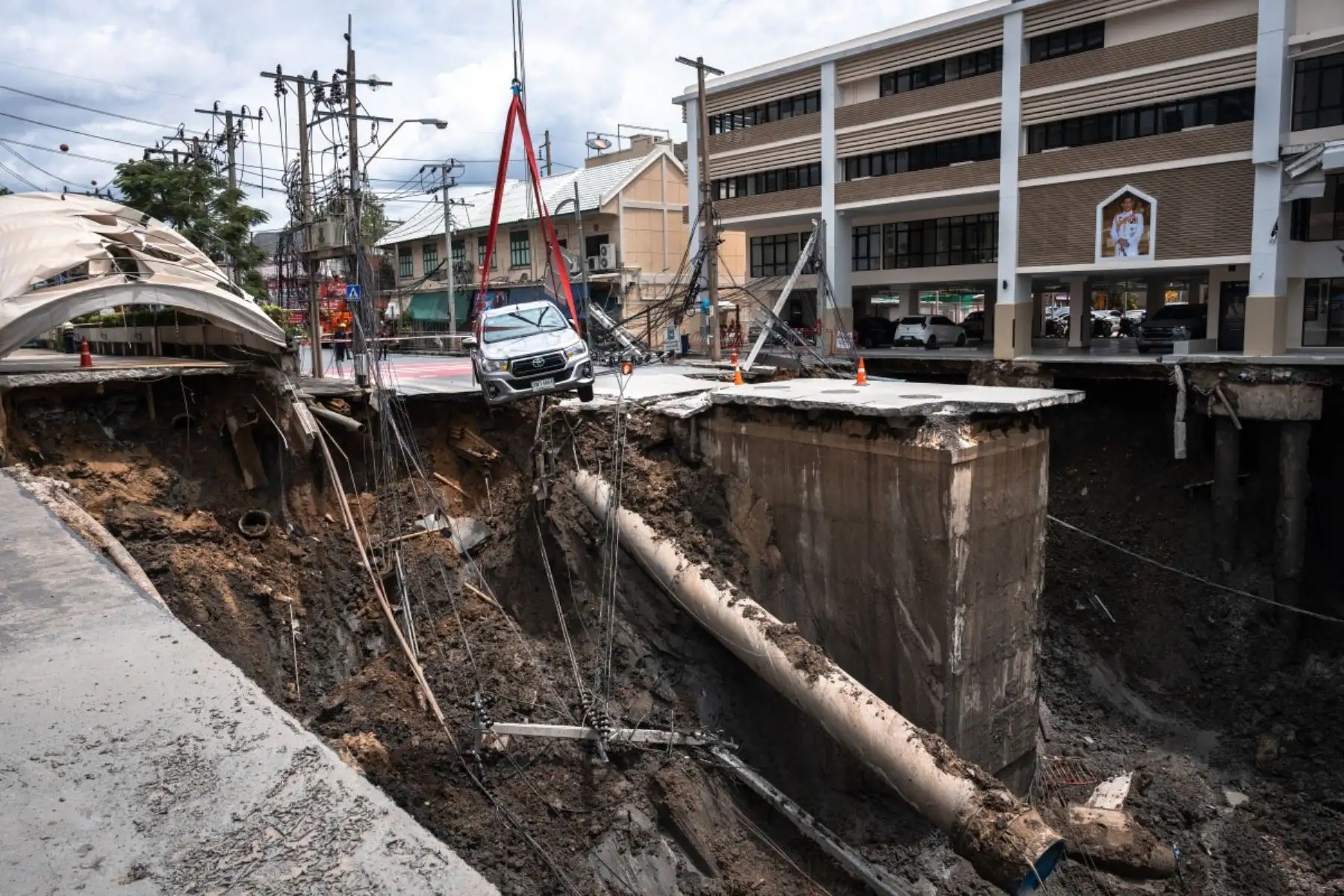 Un vehículo es retirado del borde de un agujero en el suelo de 50 metros de profundidad después de que una carretera se derrumbara cerca de un hospital en Bangkok, Tailandia, el 24 de septiembre de 2025. Foto: AFP