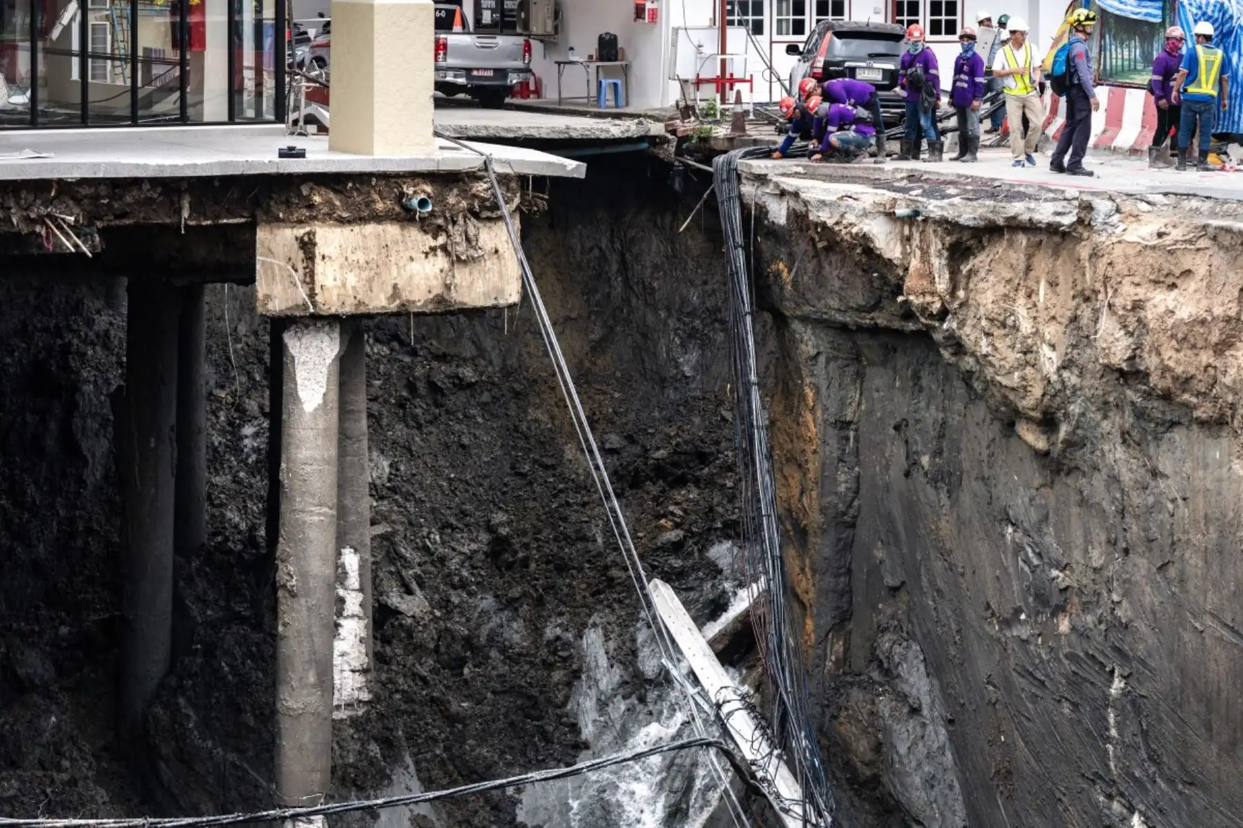 Trabajadores de emergencias inspeccionan en Bangkok, Tailandia, el agujero en el suelo de 50 metros de profundidad después de que una carretera se derrumbara cerca de un hospital el 24 de septiembre de 2025. Foto: AFP