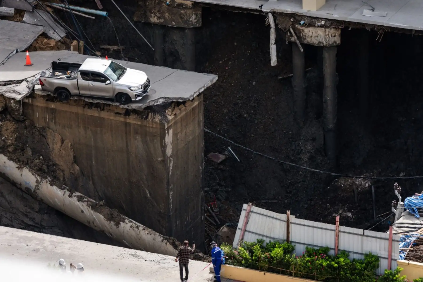 Un vehículo se encuentra al borde de un agujero en el suelo de 50 metros de profundidad después de que una carretera se derrumbara cerca de un hospital en Bangkok, Tailandia, el 24 de septiembre de 2025. Foto: AFP