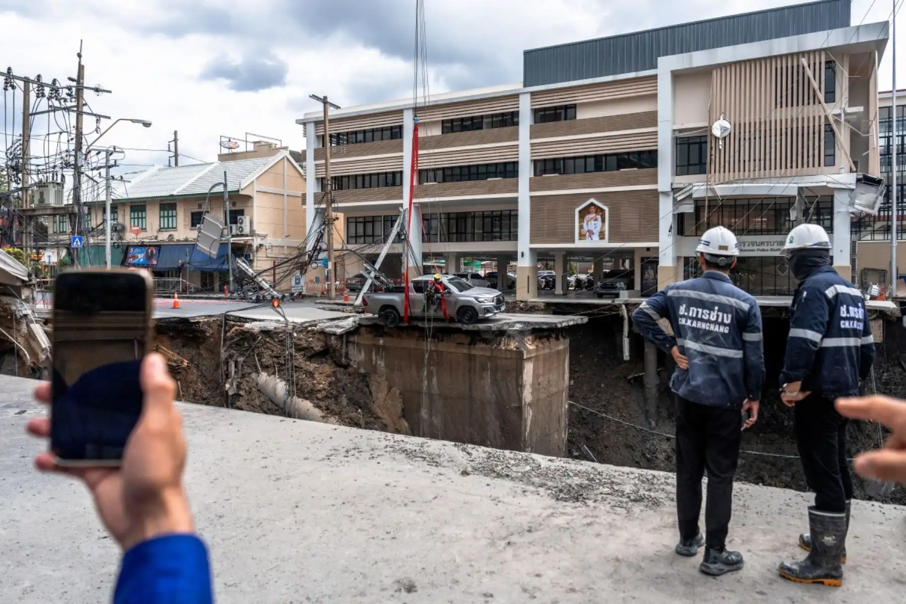 Trabajadores de emergencias intentan retirar el vehículo al borde del agujero en el suelo de 50 metros de profundidad después de que una carretera se derrumbara cerca de un hospital en Bangkok, Tailandia, el 24 de septiembre de 2025. Foto: AFP