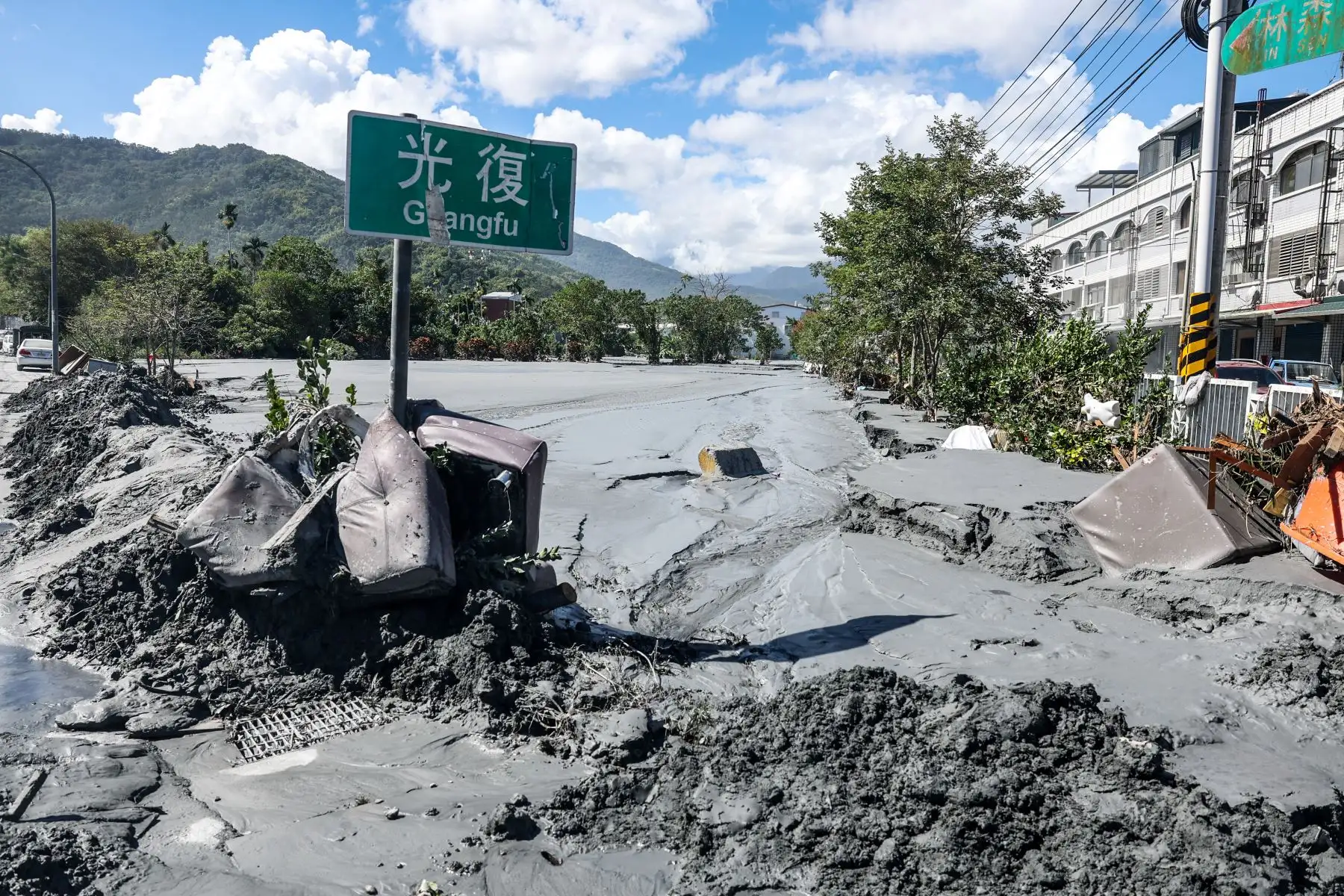Una señal de tráfico que indica Guangfu se encuentra atascada en el lodo tras el desbordamiento de un lago barrera en Hualien. Foto: AFP