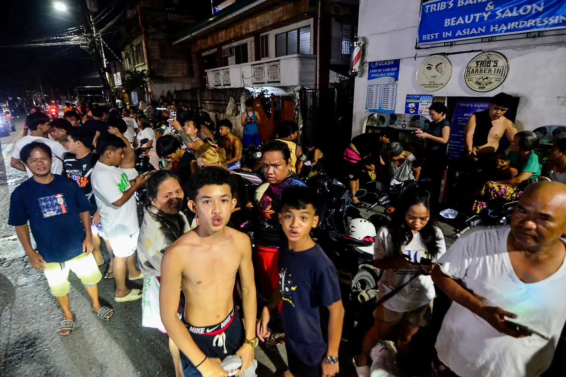 Residentes se reúnen en una calle frente a sus casas tras los temblores en Mandaue, Cebú, centro de Filipinas.
Foto: AFP