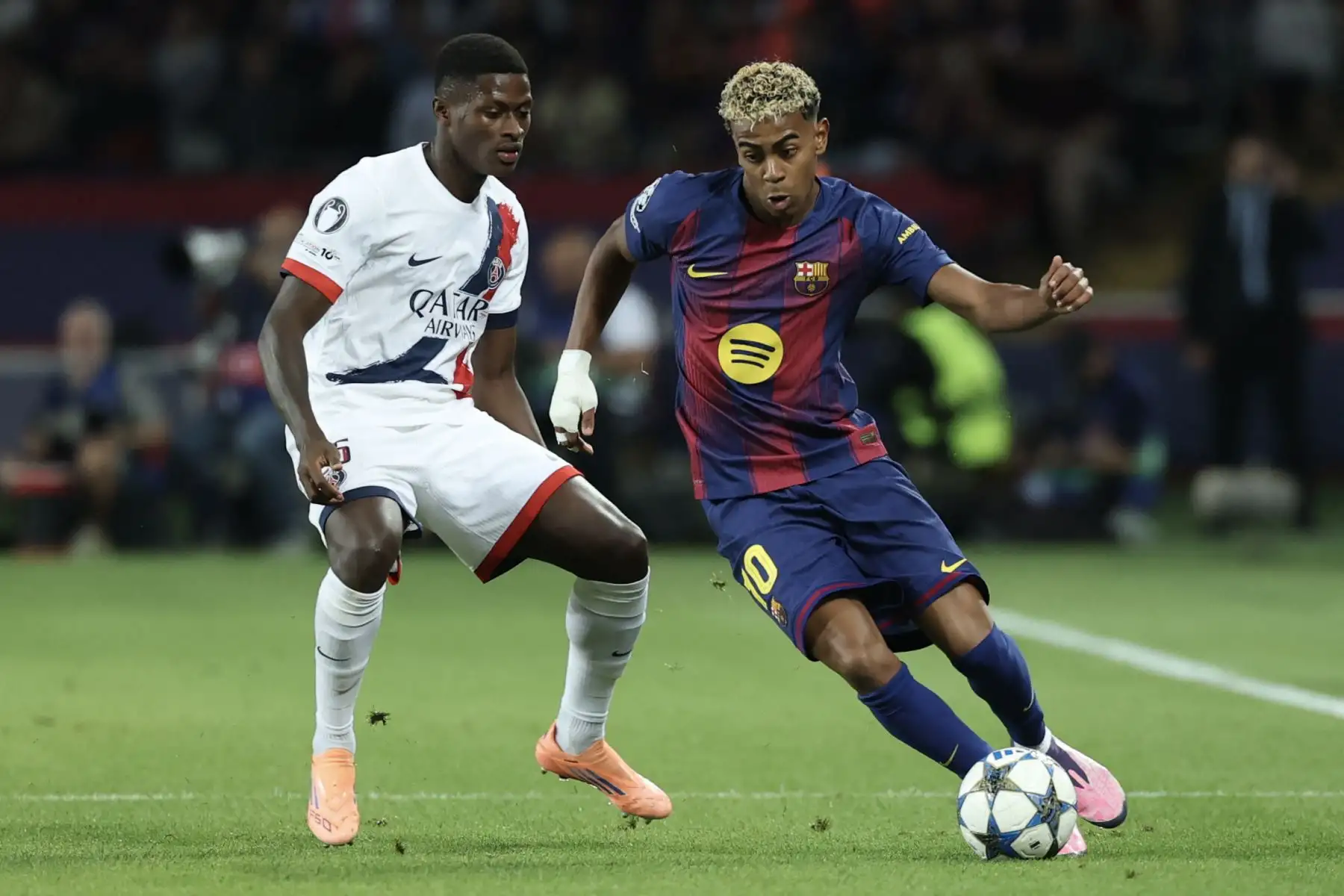 El delantero español  del Barcelona Lamine Yamal compite por el balón con el defensa portugués  del Paris Saint-Germain Nuno Mendes  durante el partido de fútbol de la jornada 2 de la fase de liga de la UEFA Champions League entre el FC Barcelona y el Paris Saint-Germain (PSG). AFP