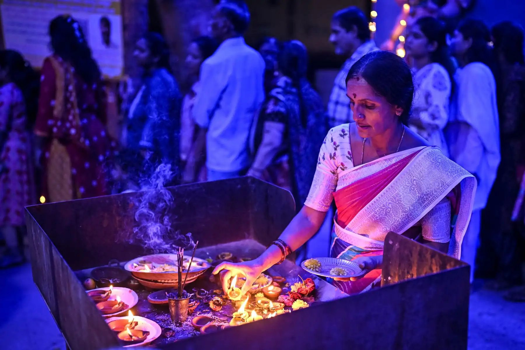 Un devoto hindú enciende una lámpara de barro para ofrecer oraciones a la diosa Durga con motivo del festival Durga Puja en el templo Om Shakthi en Bengaluru. AFP