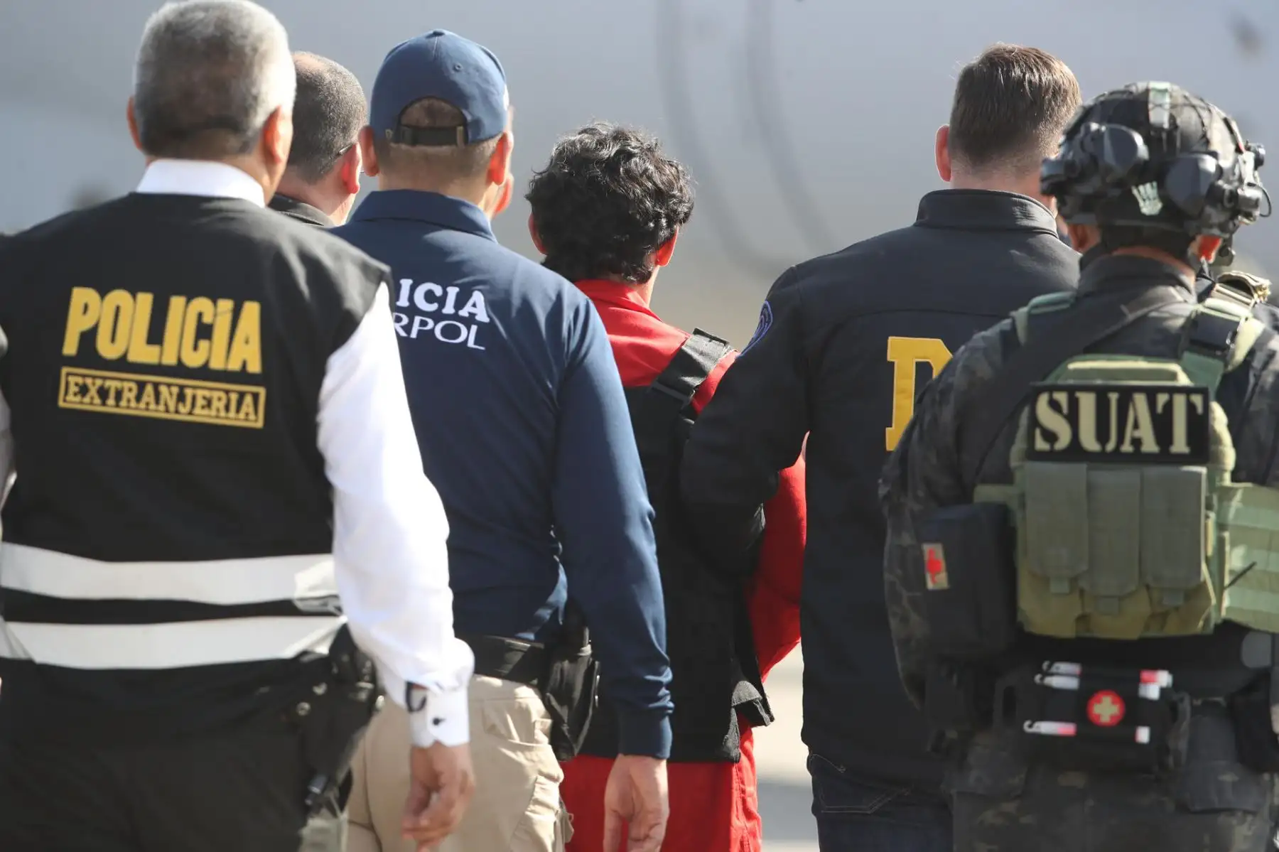 Matías Agustín Ozorio, de nacionalidad argentina, es trasladado por integrantes de la Policía Nacional de Perú y de Interpol para ser entregado a la Policía Argentina este jueves, en la Base Aérea de Policía Aérea de Perú en Lima (Perú). EFE