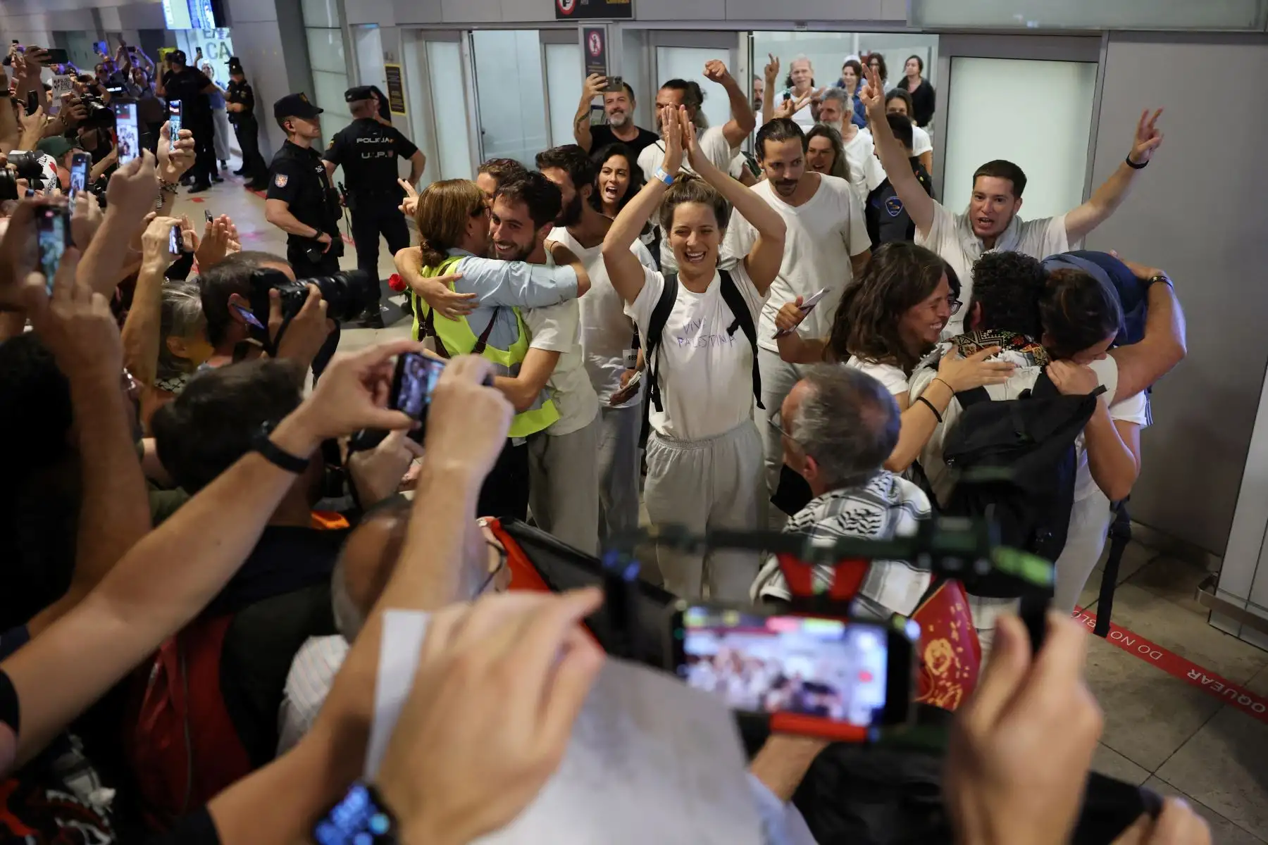 Activistas españoles  que navegaban a bordo de los buques de la Flotilla Global Sumud aplauden a su llegada al aeropuerto de Madrid-Barajas, después de que Israel detuviera la flotilla de ayuda con destino a Gaza y detuviera a cientos de personas.  Foto: AFP