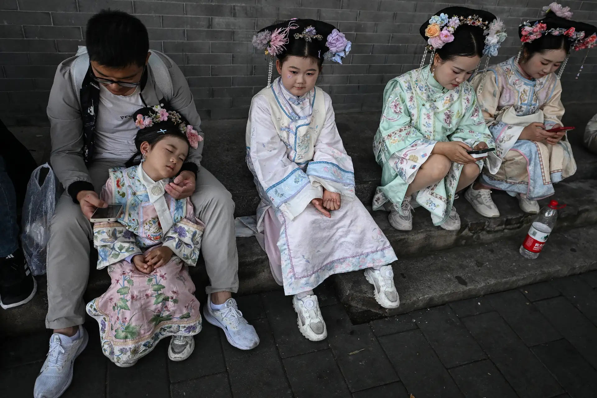 Niñas con trajes tradicionales chinos descansan mientras visitan una zona turística en Beijing durante la Semana Dorada del Día Nacional de China.
Foto: AFP