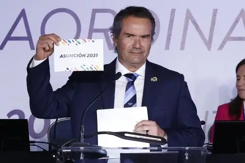 El Presidente de Panam Sports, Neven Ilic, muestra en un cartel el nombre de la ciudad de Asunción, elegida para ser sede de los juegos Panamericanos y Parapanamericanos 2031, este viernes en Santiago (Chile). La ciudad de Asunción fue elegida como la sede de los Juegos Panamericanos 2031, en una asamblea general extraordinaria de Panam Sports los 41 Comités Olímpicos del continente. Foto: EFE