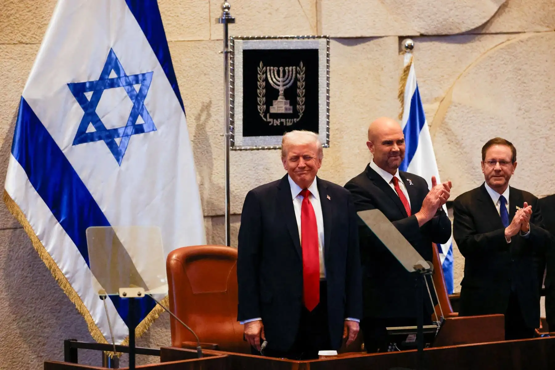 El presidente estadounidense Donald Trump aplaude junto al presidente israelí Isaac Herzog y el presidente de la Knéset, Amir Ohana, en el parlamento israelí, la Knéset, en Jerusalén. Foto: AFP