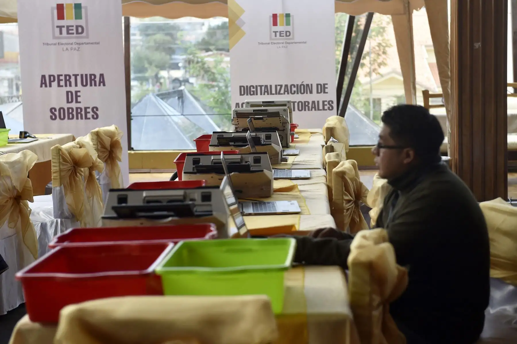 Un funcionario del Tribunal Supremo Electoral  de Bolivia instala equipos en el área donde funcionará el Sistema de Transmisión y Publicación de Resultados Preliminares , previo a la segunda vuelta de las elecciones presidenciales, en La Paz, el 18 de octubre de 2025. 
Foto: AFP