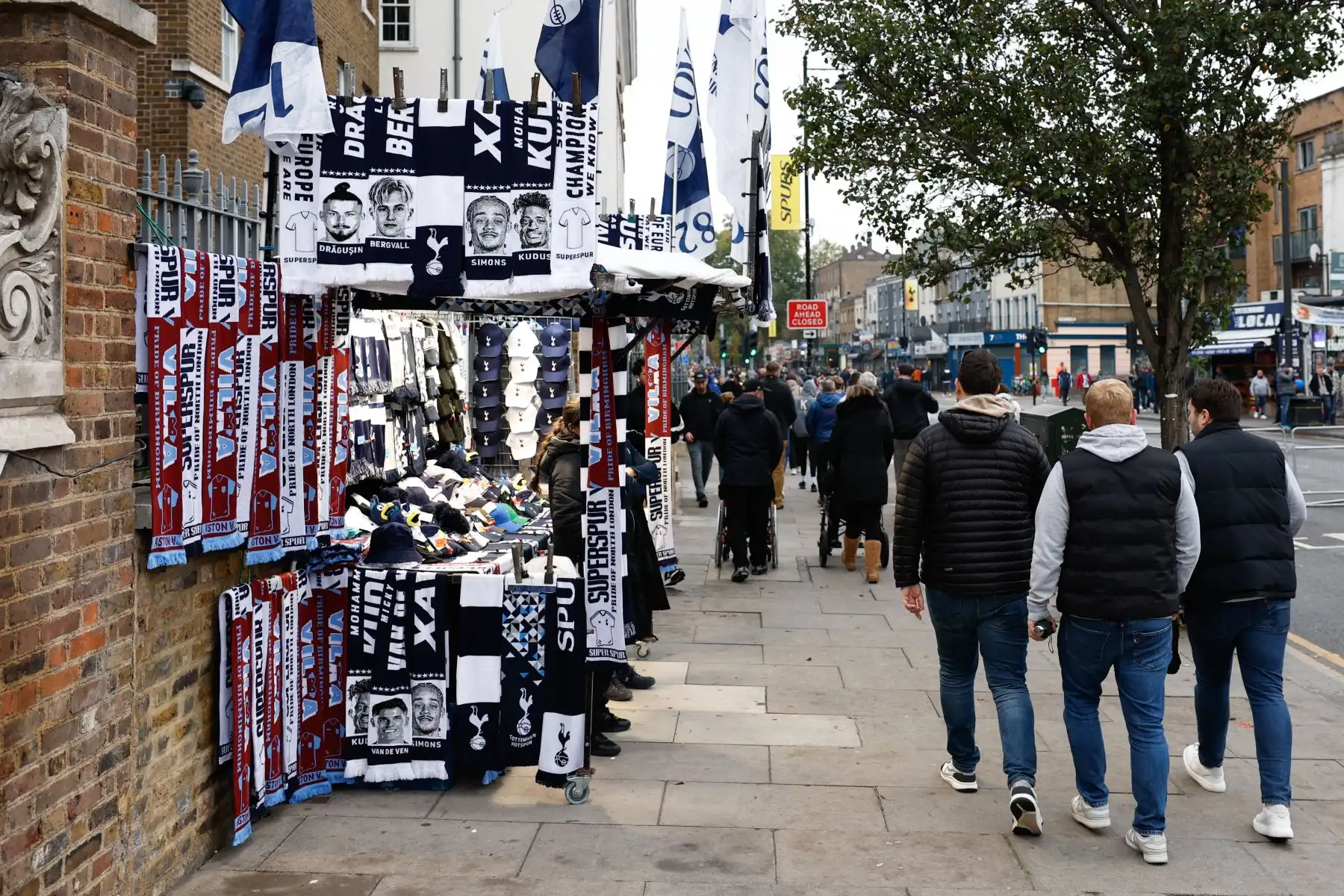 Aficionados pasean junto a puestos de recuerdos en el exterior del estadio del Tottenham Hotspur antes del partido de la Premier League inglesa entre el Tottenham Hotspur y el Aston Villa, en Londres, Gran Bretaña. Foto: ANDINA/ EFE