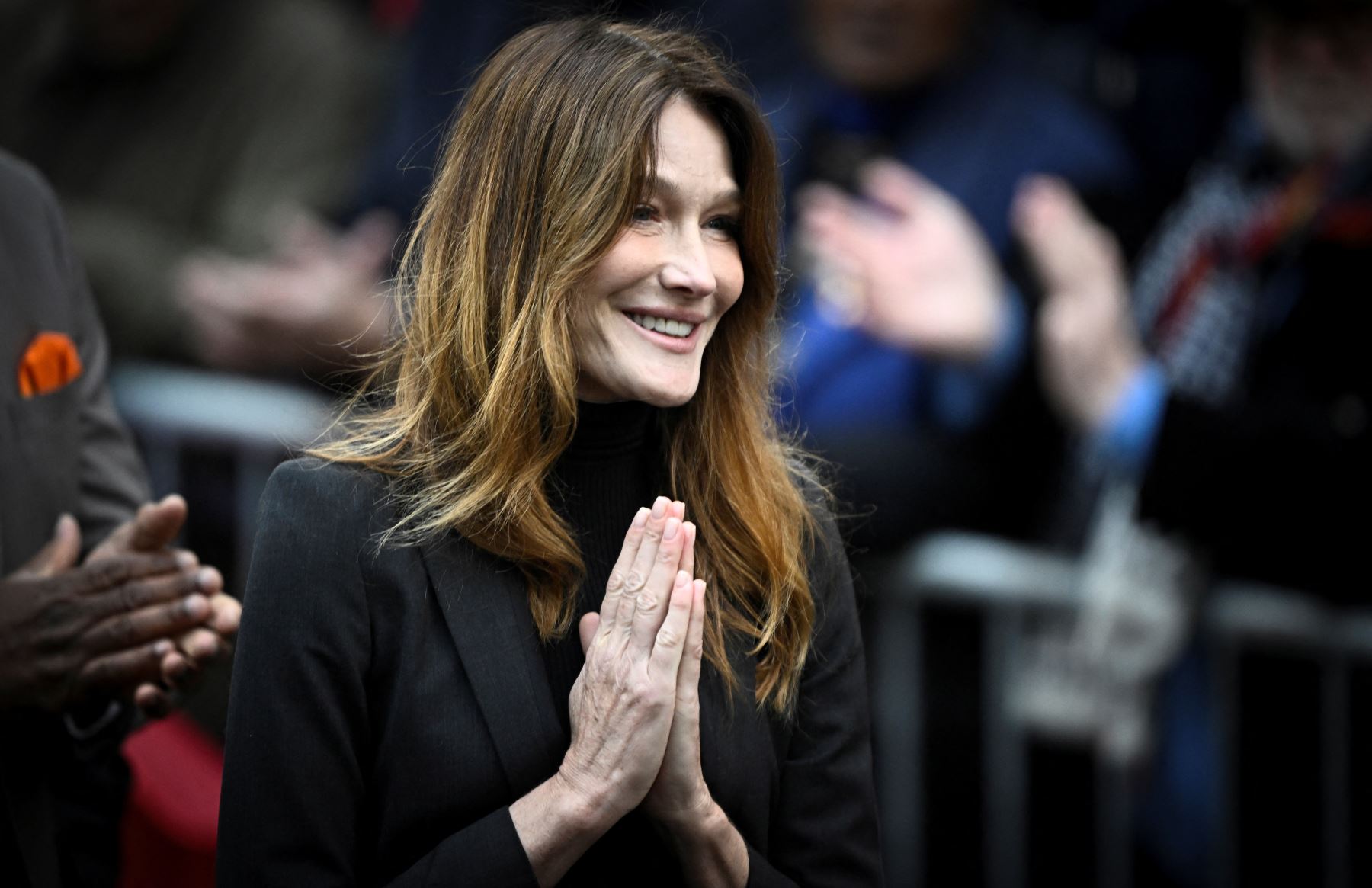 Carla Bruni-Sarkozy, esposa del expresidente francés Nicolas Sarkozy, reacciona cuando su esposo sale de su residencia para presentarse en la prisión de La Santé para cumplir una condena de cinco años de prisión tras ser declarado culpable de conspiración criminal por un plan para que el difunto dictador libio Muamar el Gadafi financiara su campaña electoral de 2007. Foto: AFP