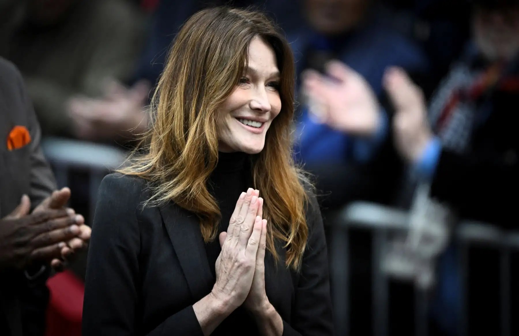 Carla Bruni-Sarkozy, esposa del expresidente francés Nicolas Sarkozy, reacciona cuando su esposo sale de su residencia para presentarse en la prisión de La Santé para cumplir una condena de cinco años de prisión tras ser declarado culpable de conspiración criminal por un plan para que el difunto dictador libio Muamar el Gadafi financiara su campaña electoral de 2007. Foto: AFP