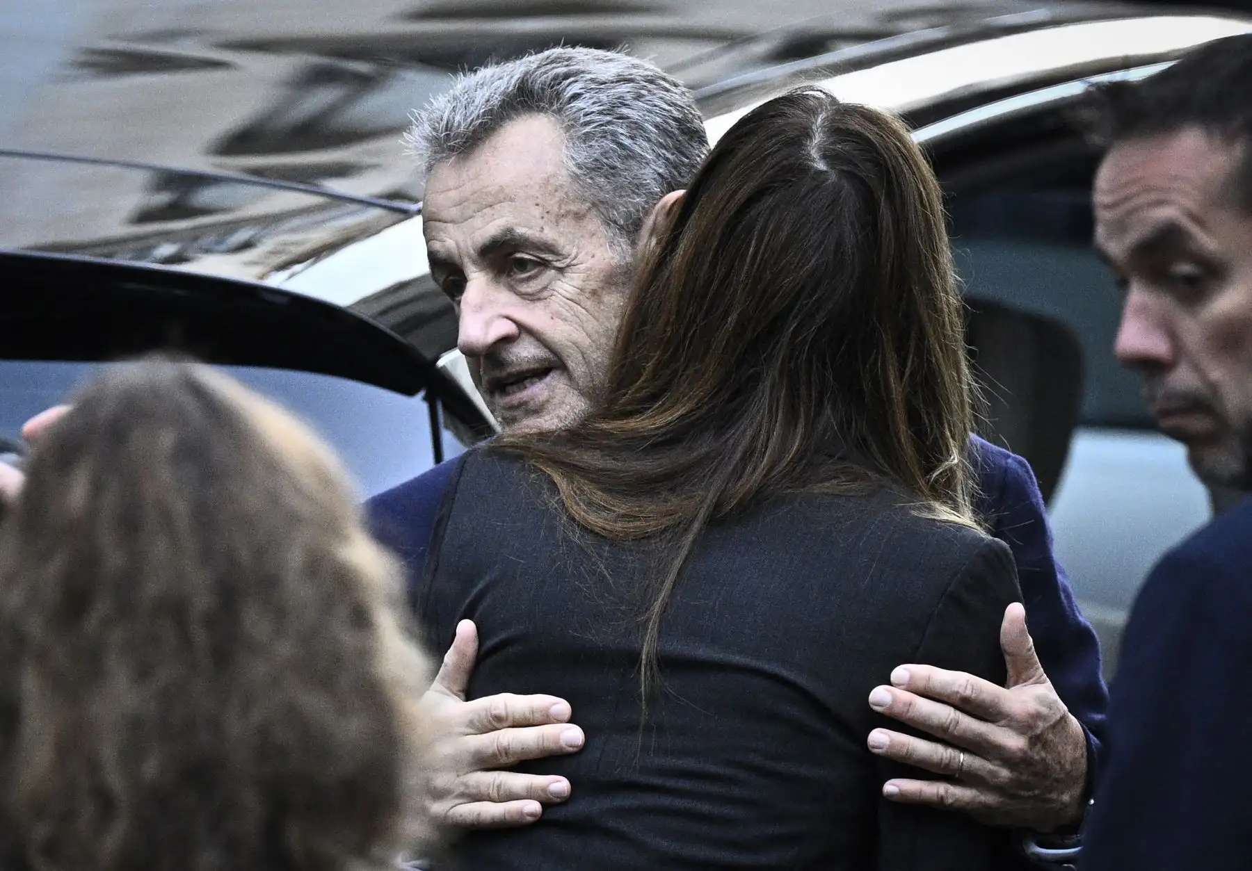 El expresidente francés Nicolas Sarkozy abraza a su esposa Carla Bruni-Sarkozy al salir de su residencia para presentarse en la prisión de La Santé, donde cumplirá una condena de cinco años de prisión tras ser declarado culpable de conspiración criminal por un plan para que el difunto dictador libio Muamar el Gadafi financiara su campaña electoral de 2007. Foto: AFP