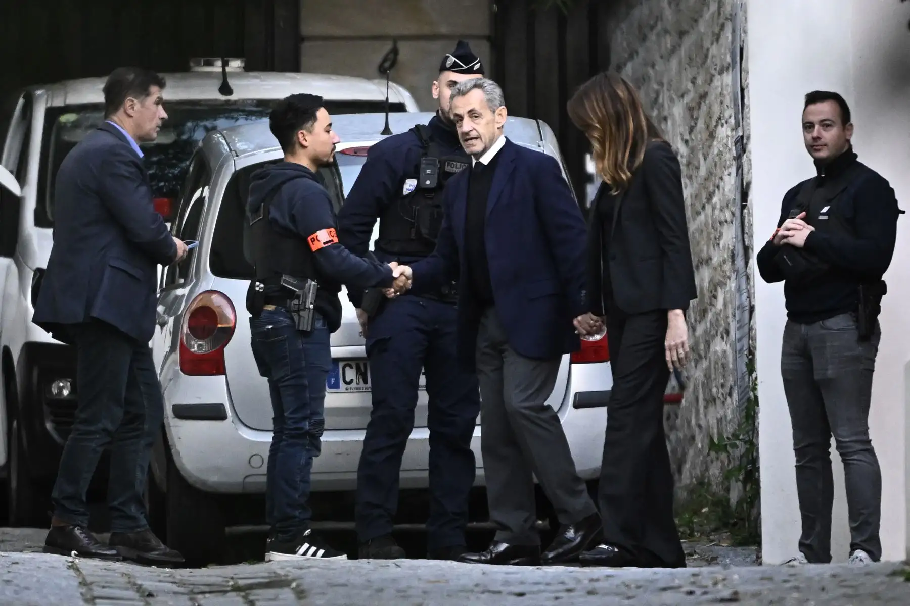 El expresidente francés Nicolas Sarkozy, acompañado de su esposa Carla Bruni-Sarkozy, sale de su residencia para presentarse en la prisión de La Santé y cumplir una condena de cinco años de prisión tras ser declarado culpable de conspiración criminal por un plan para que el difunto dictador libio Muamar el Gadafi financiara su campaña electoral de 2007. Foto: AFP