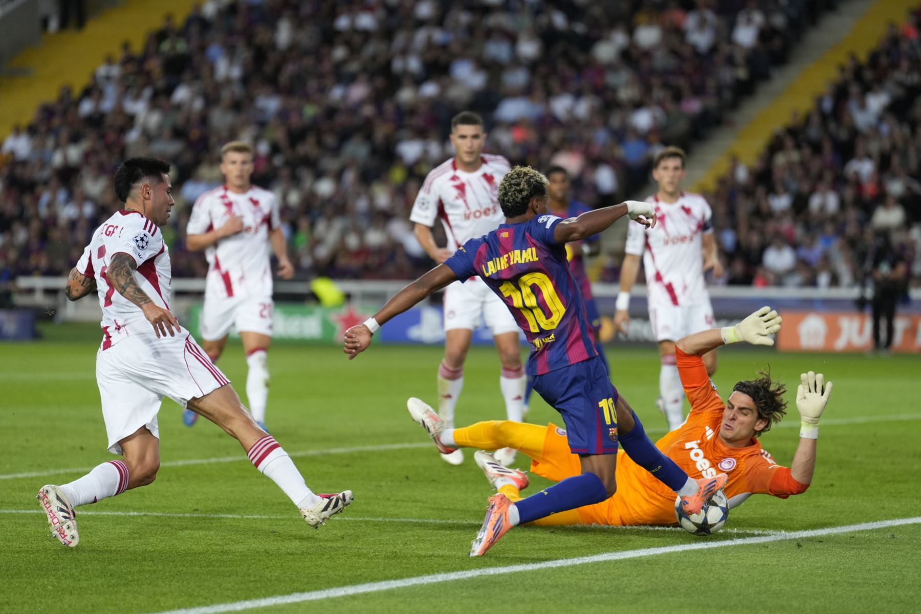 El delantero del Barcelona lamine Yamal y el portero de Olimpiacos Konstantinos Tzolakis, durante el partido de la jornada 3 de la Liga de Campeones entre el Barcelona y el Olimpiacos, este martes en el Estadi Olímpic Lluís Companys. Foto: EFE