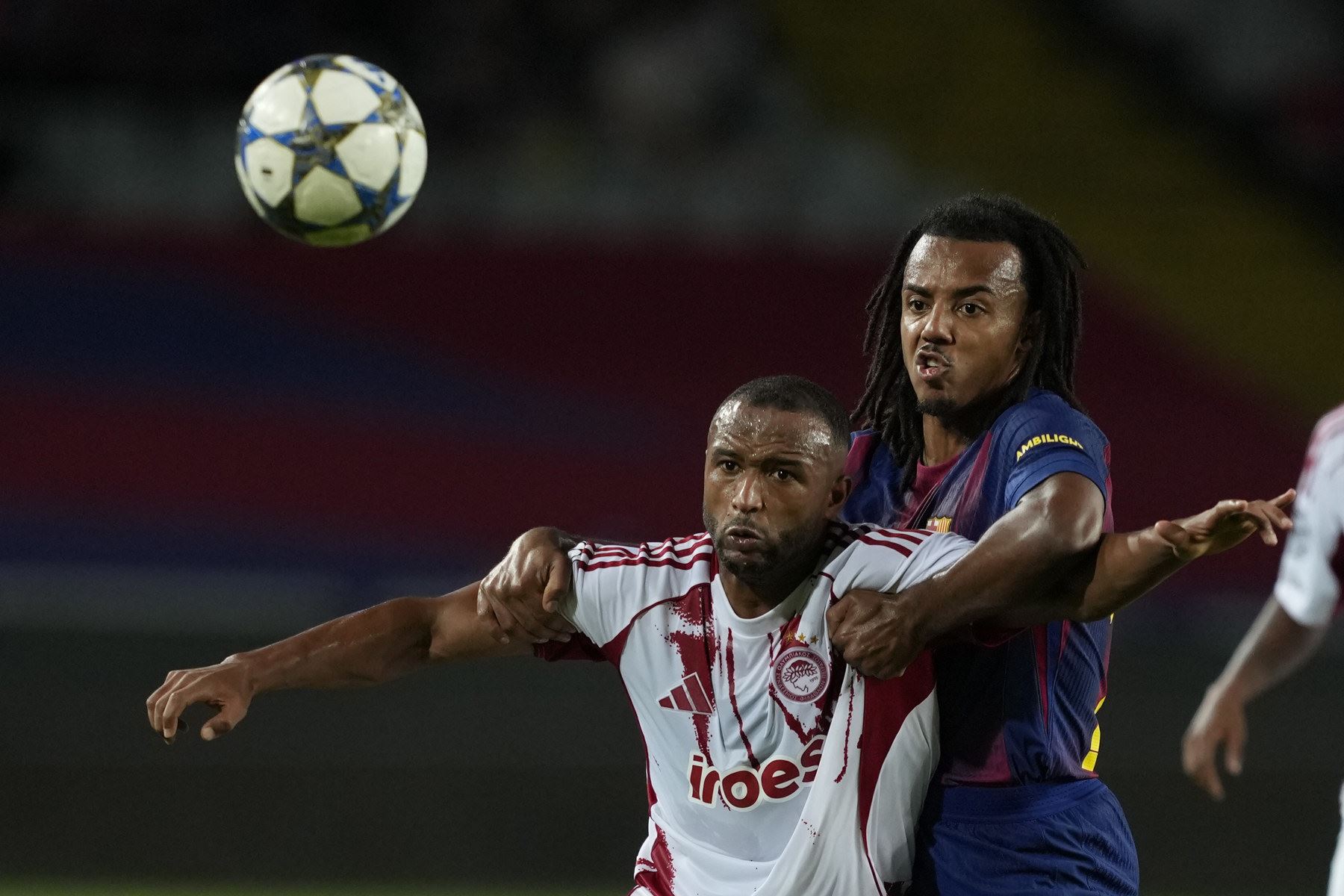 El defensa del Barcelona Koundé (dcha) pelea por el control del balón con el jugador de Olympiacos Ayoub El Kaabi, durante el partido de la jornada 3 de la Liga de Campeones entre el Barcelona y el Olympiacos, este martes en el Estadio Olímpic Lluís Companys. Foto: EFE