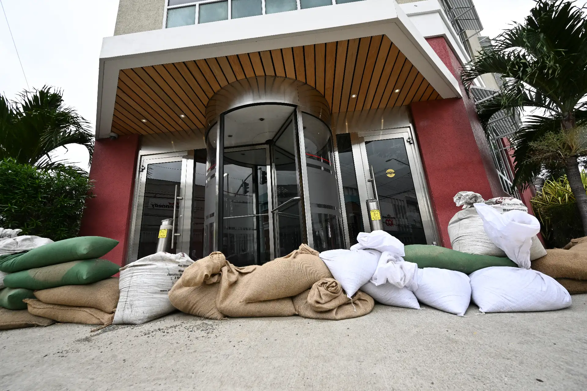 Se colocan sacos de arena a la entrada del edificio Grace Kennedy en preparación para la llegada del huracán Melissa al centro de Kingston, Jamaica, el 25 de octubre de 2025. La mortal tormenta Melissa se fortaleció el sábado por la tarde hasta convertirse en un huracán de categoría 1, y se espera una rápida intensificación durante el fin de semana, siguiendo un rumbo preocupantemente lento hacia la isla caribeña de Jamaica, según los meteorólogos.
Foto: AFP Se colocan sacos de arena a la entrada del edificio Grace Kennedy en preparación para la llegada del huracán Melissa al centro de Kingston, Jamaica, el 25 de octubre de 2025. La mortal tormenta Melissa se fortaleció el sábado por la tarde hasta convertirse en un huracán de categoría 1, y se espera una rápida intensificación durante el fin de semana, siguiendo un rumbo preocupantemente lento hacia la isla caribeña de Jamaica, según los meteorólogos.
Foto: AFP
