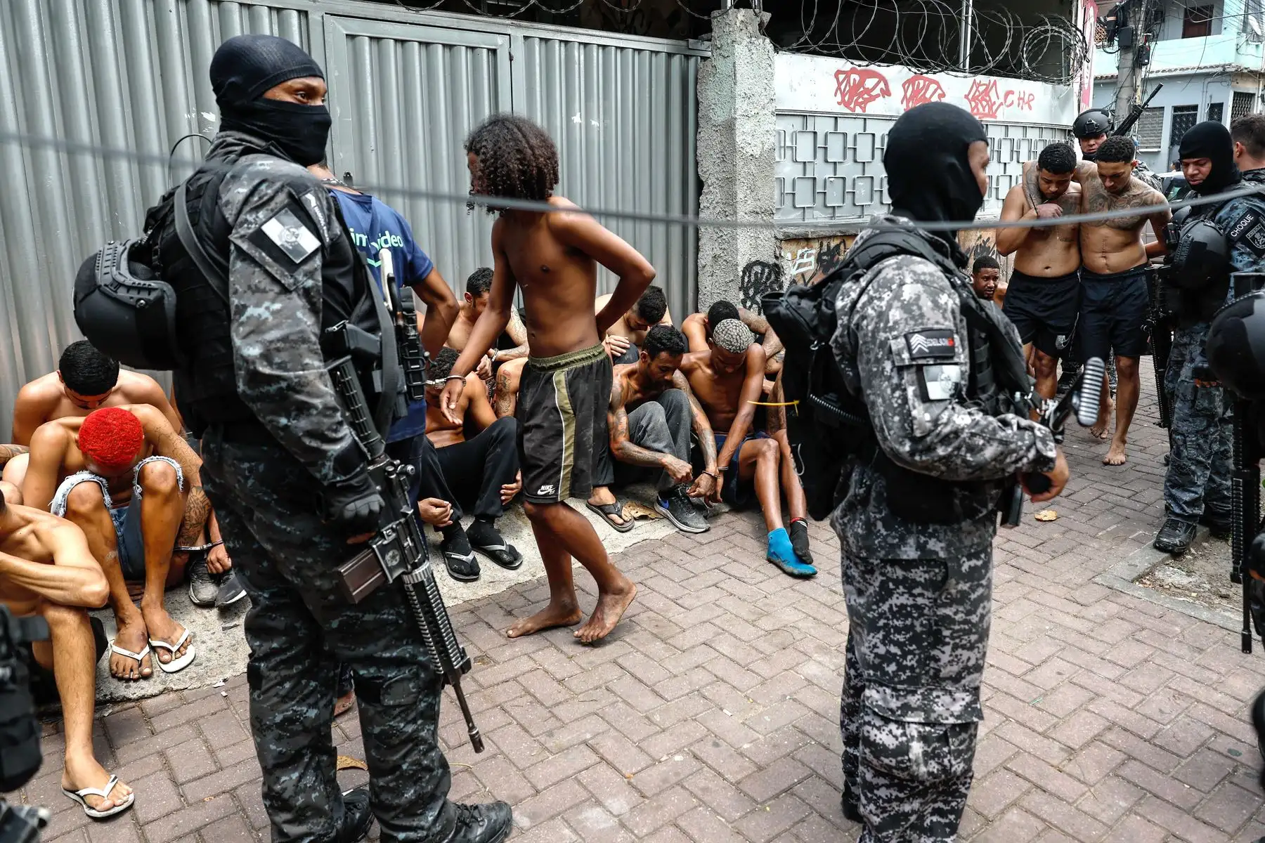 Integrantes de la Policía de Río de Janeiro trasladan a un grupo de personas durante un operativo este martes, en Río de Janeiro (Brasil). Al menos veinte personas murieron y medio centenar fueron detenidas en medio de una gran operación policial contra el Comando Vermelho, una de las más poderosas bandas del crimen organizado de Río de Janeiro. Foto: EFE Integrantes de la Policía de Río de Janeiro trasladan a un grupo de personas durante un operativo este martes, en Río de Janeiro (Brasil). Al menos veinte personas murieron y medio centenar fueron detenidas en medio de una gran operación policial contra el Comando Vermelho, una de las más poderosas bandas del crimen organizado de Río de Janeiro. Foto: EFE