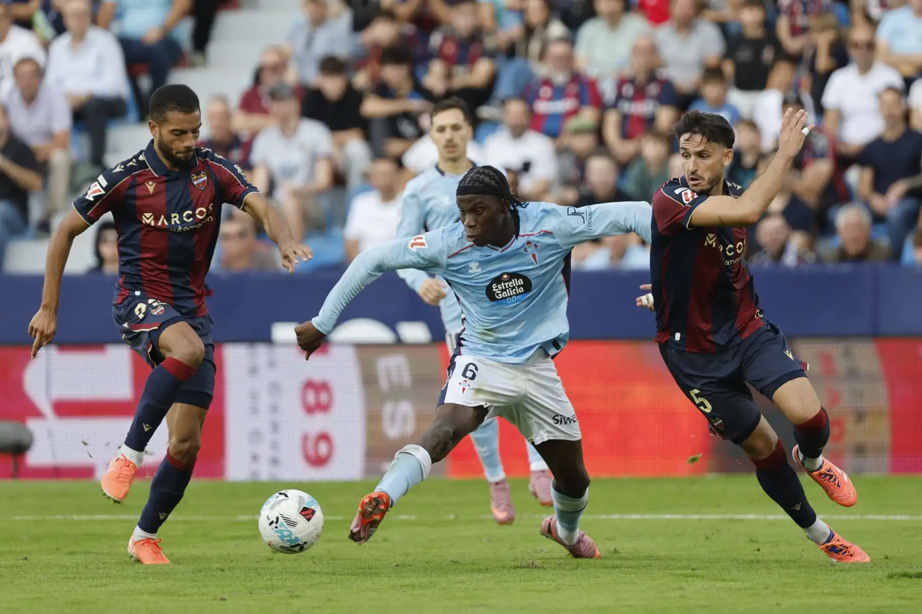 El centrocampista del Celta de Vigo Ilaix Moriba lucha por el balón con los defensas Jeremy Toljan y Unai Elgezabal, del Levante, durante el partido correspondiente a la undécima jornada de LaLiga EA Sports disputado este domingo en el Ciutat de València. Foto: ANDINA/EFE