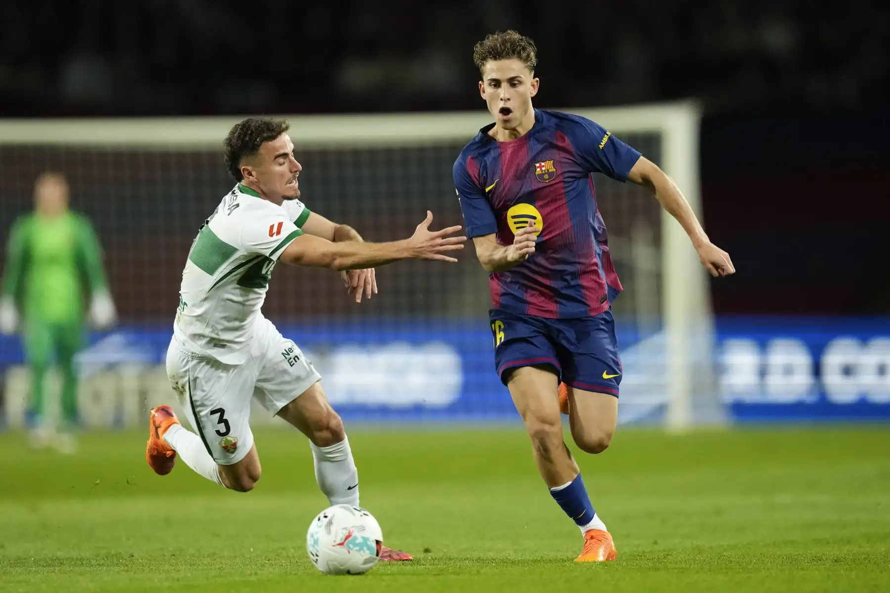 El centrocampista del Barcelona Fermín López (d) se escapa de Adrià Pedrosa, del Elche, durante el partido de LaLiga entre el FC Barcelona y el Elche CF, este domingo en el estadio Olímpico Lluis Companys. EFE/Enric Fontcuberta