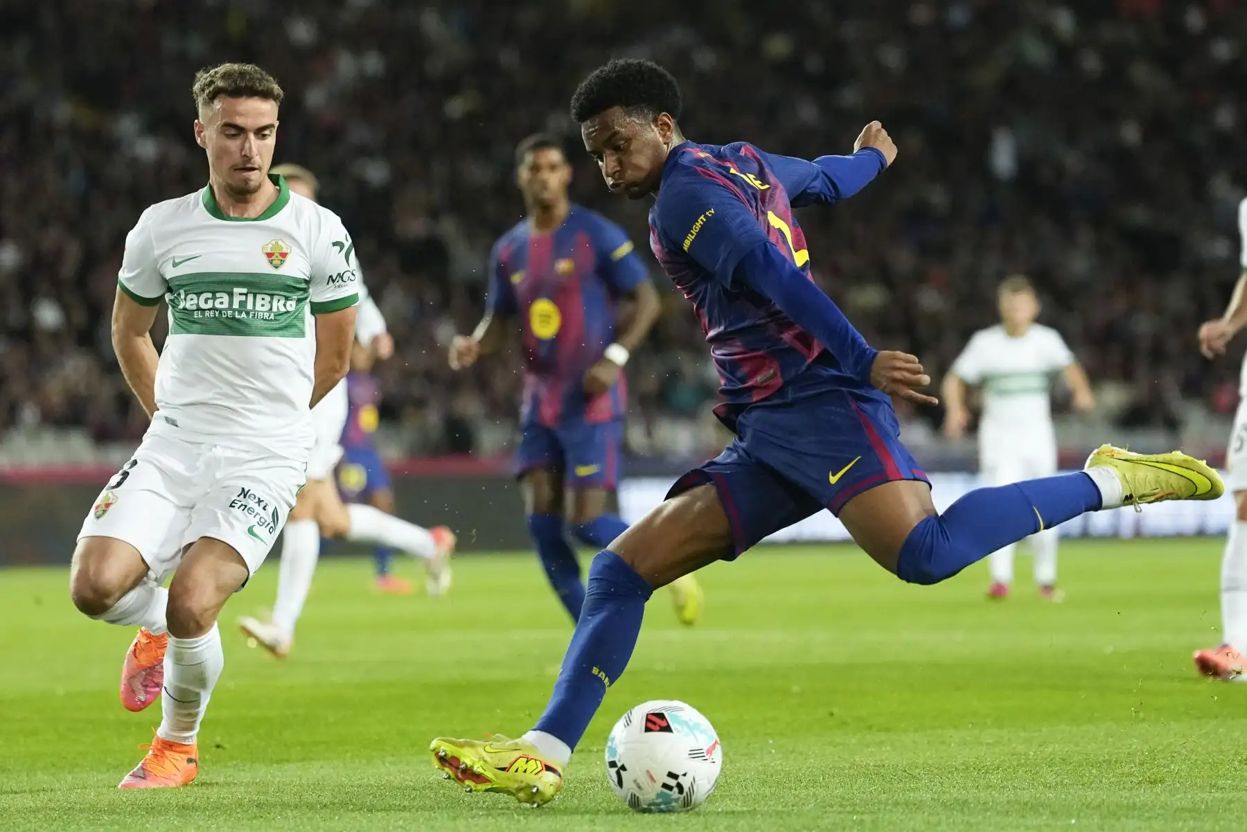 El defensa del Barcelona Alex Balde (d) pelea un balón con Marc Aguado, del Elche, durante el partido de LaLiga entre el FC Barcelona y el Elche CF, este domingo en el estadio Olímpico Lluis Companys. EFE/ Enric Fontcuberta