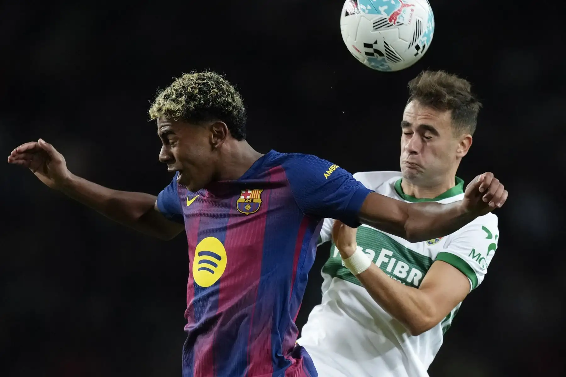 El delantero del Barcelona Lamine Yamal (i) lucha con Álvaro Núñez, del Elche, durante el partido de LaLiga entre el FC Barcelona y el Elche CF, este domingo en el estadio Olímpico Lluis Companys. EFE/Enric Fontcuberta