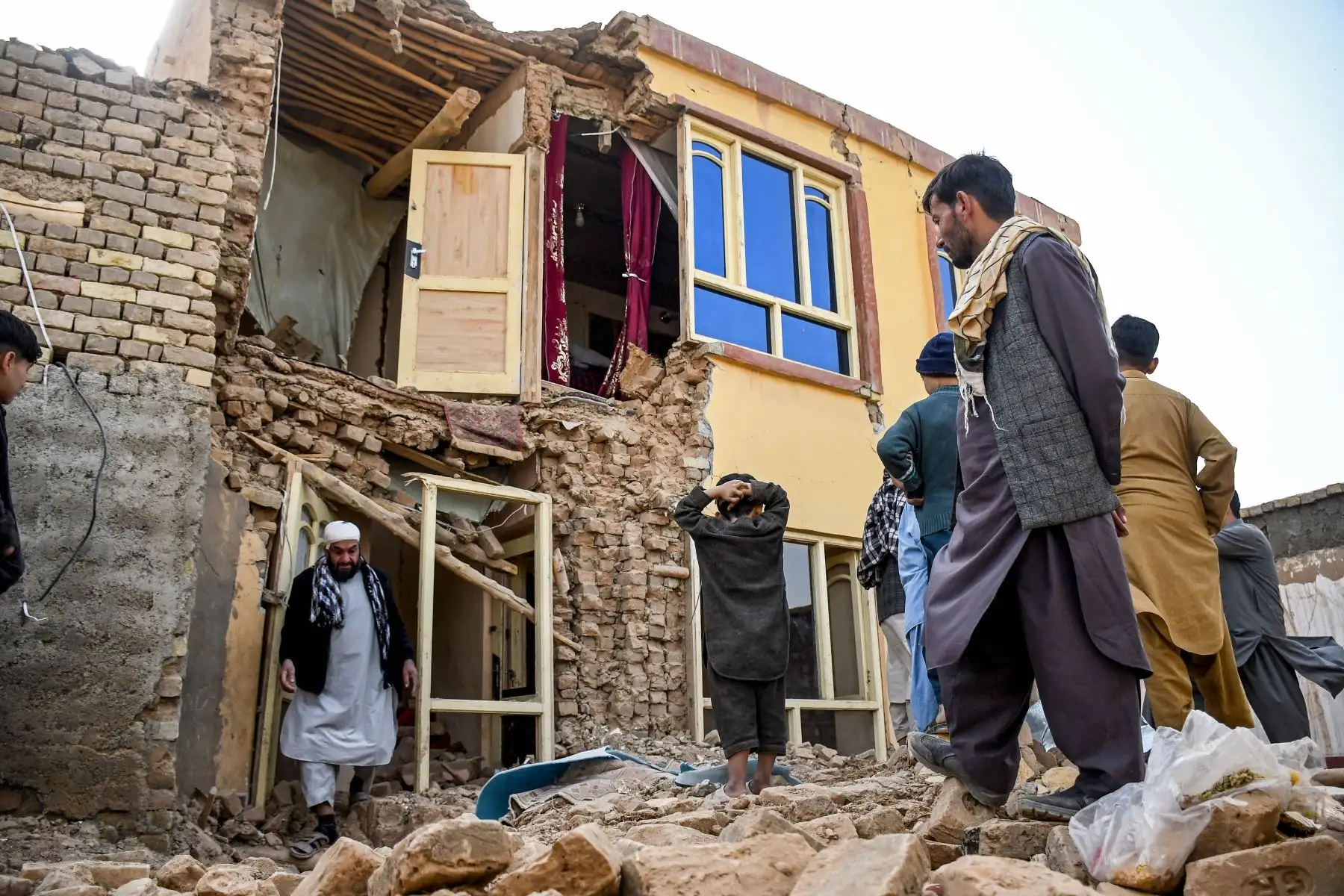 Sobrevivientes del terremoto afgano buscan entre los restos de una casa dañada en una aldea de Tashqurghan, en el distrito de Khulm, provincia de Samangan, el 3 de noviembre de 2025. Un fuerte terremoto de magnitud 6.3 que sacudió el norte de Afganistán durante la noche causó la muerte de al menos 20 personas. Foto: ANDINA/ AFP