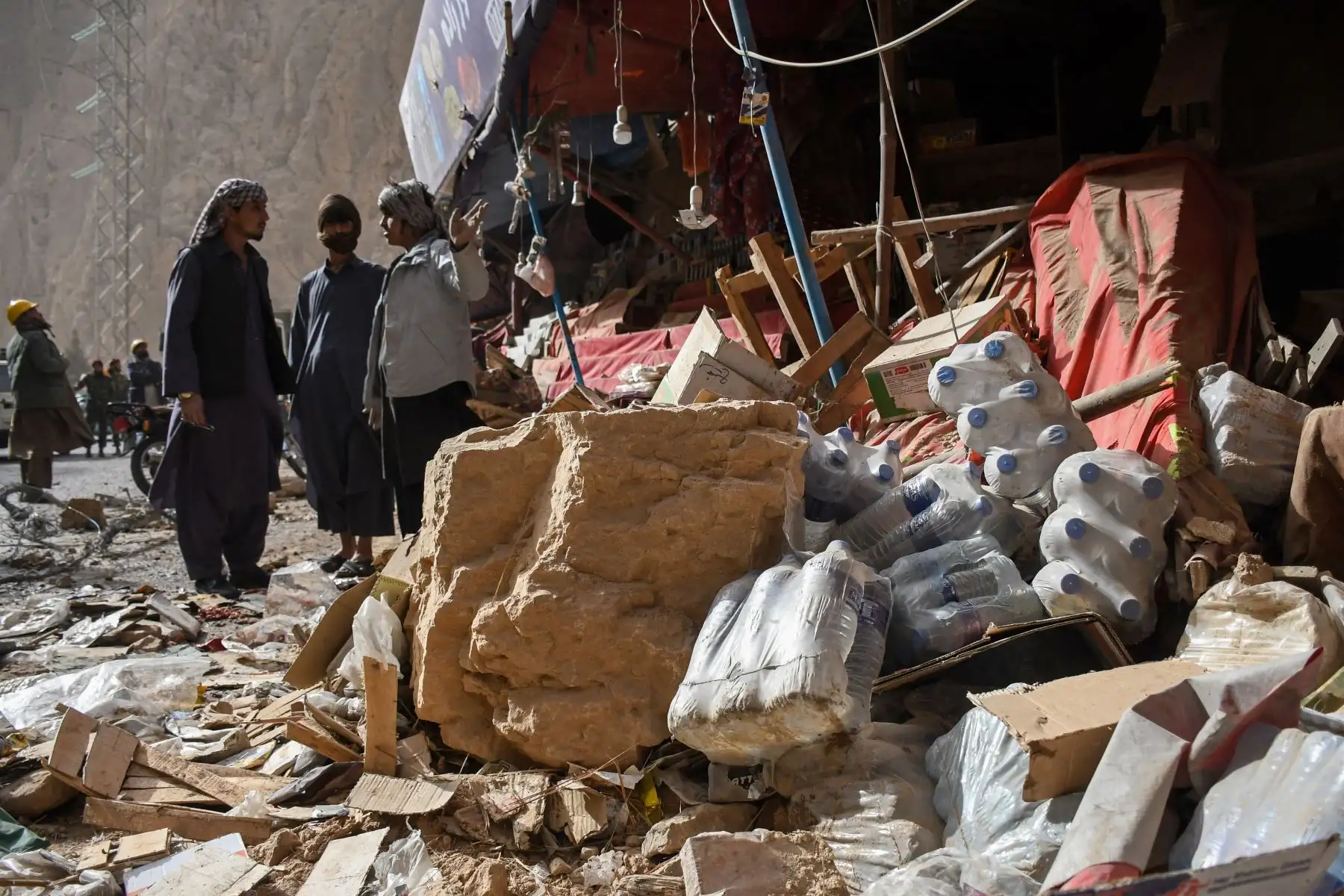 Comerciantes afganos buscan entre los restos de sus tiendas dañadas a lo largo de una carretera, tras el terremoto que sacudió Tang-e Tashkurgan, en el distrito de Khulm, provincia de Samangan, el 3 de noviembre de 2025. Un fuerte terremoto dejó al menos 20 muertos en el norte de Afganistán. Foto: ANDINA/AFP