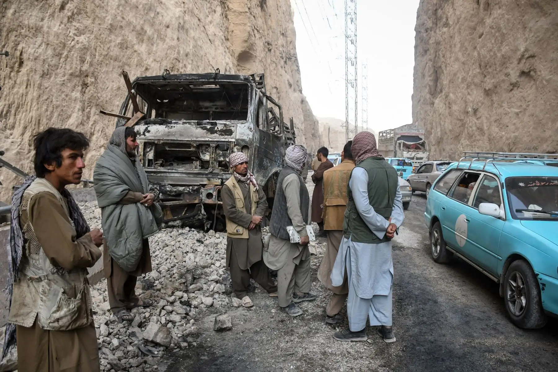 Hombres afganos inspeccionan los restos calcinados de un camión junto a una carretera, tras el terremoto que sacudió Tang-e Tashkurgan, en el distrito de Khulm, provincia de Samangan, el 3 de noviembre de 2025. Un fuerte terremoto dejó al menos 20 muertos en el norte de Afganistán. Foto: ANDINA/AFP