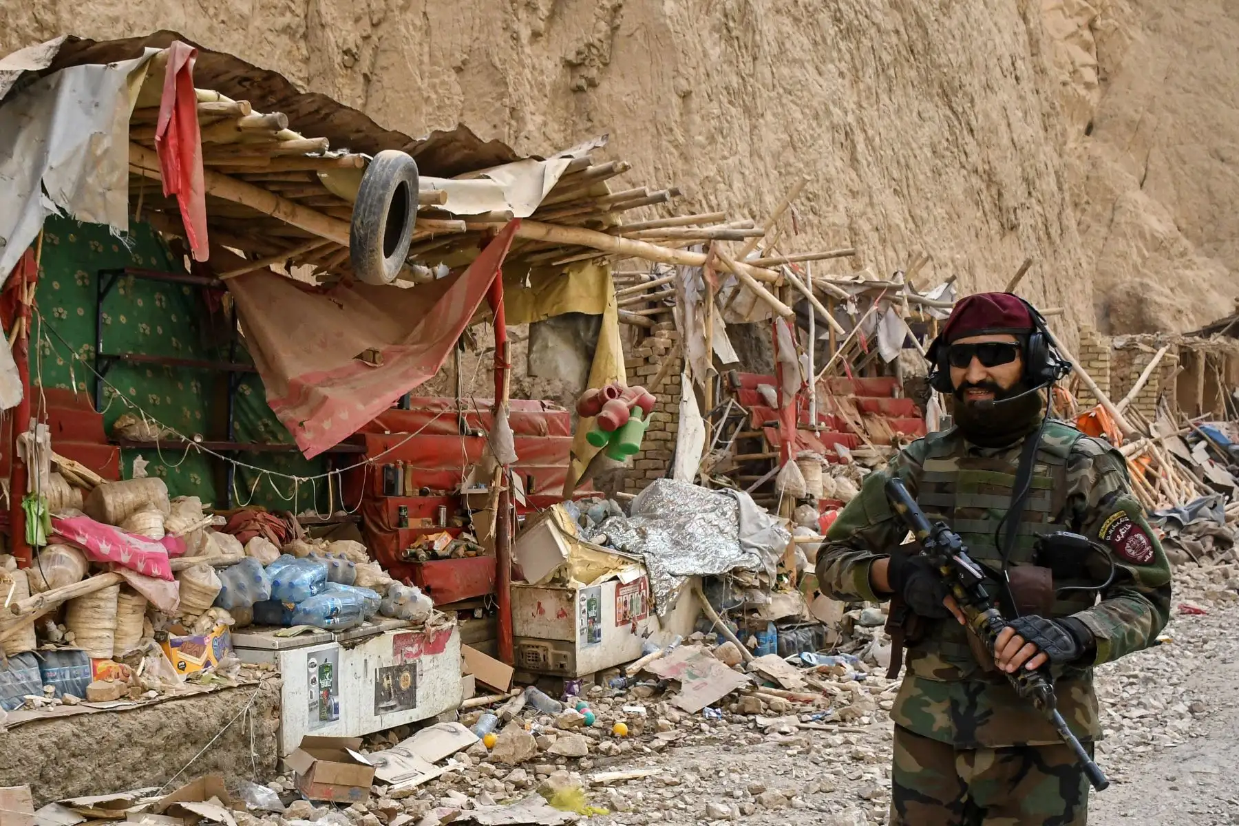 Un miembro de las fuerzas de seguridad talibanes camina junto a tiendas dañadas a lo largo de una carretera, tras el terremoto que sacudió Tang-e Tashkurgan, en el distrito de Khulm, provincia de Samangan, el 3 de noviembre de 2025. Un fuerte terremoto dejó al menos 20 muertos en el norte de Afganistán. Foto:ANDINA/ AFP