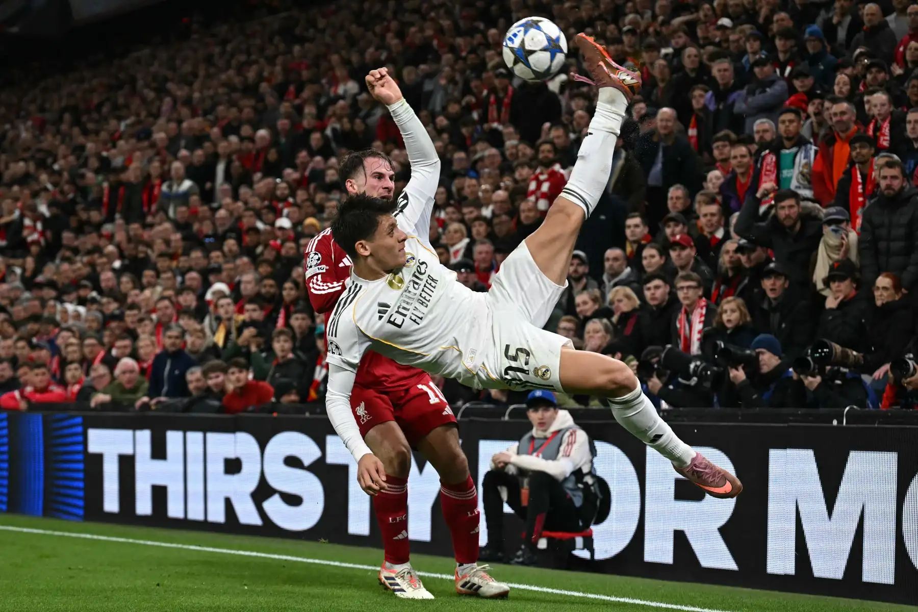 El centrocampista turco del Real Madrid, Arda Güler  disputa el balón con el centrocampista argentino del Liverpool, Alexis Mac Allister , durante el partido de la fase de grupos de la UEFA Champions League entre el Liverpool y el Real Madrid. AFP