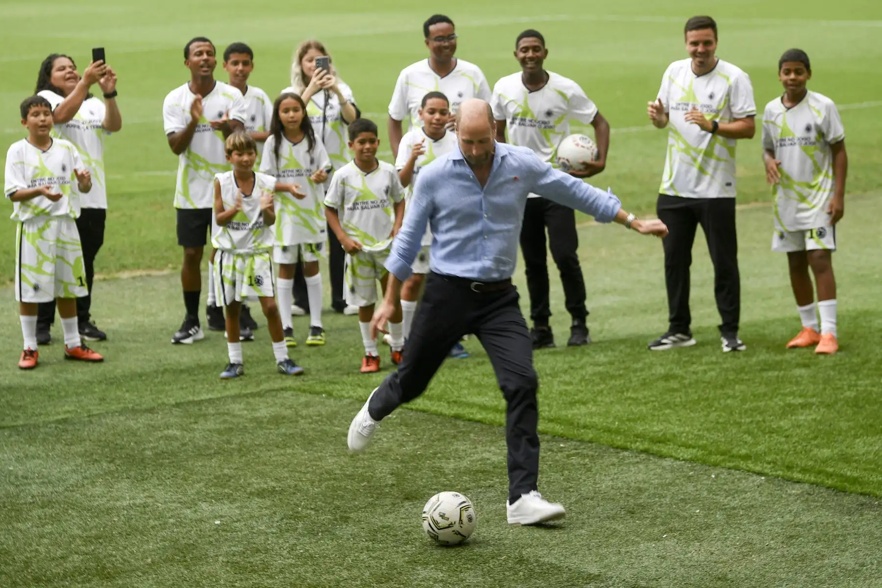 El príncipe Guillermo de Gran Bretaña, príncipe de Gales, se prepara patear el balón durante el evento "Fútbol Comunitario" con niños que participan en proyectos sociales, en el estadio Maracaná de Río de Janeiro. AFP