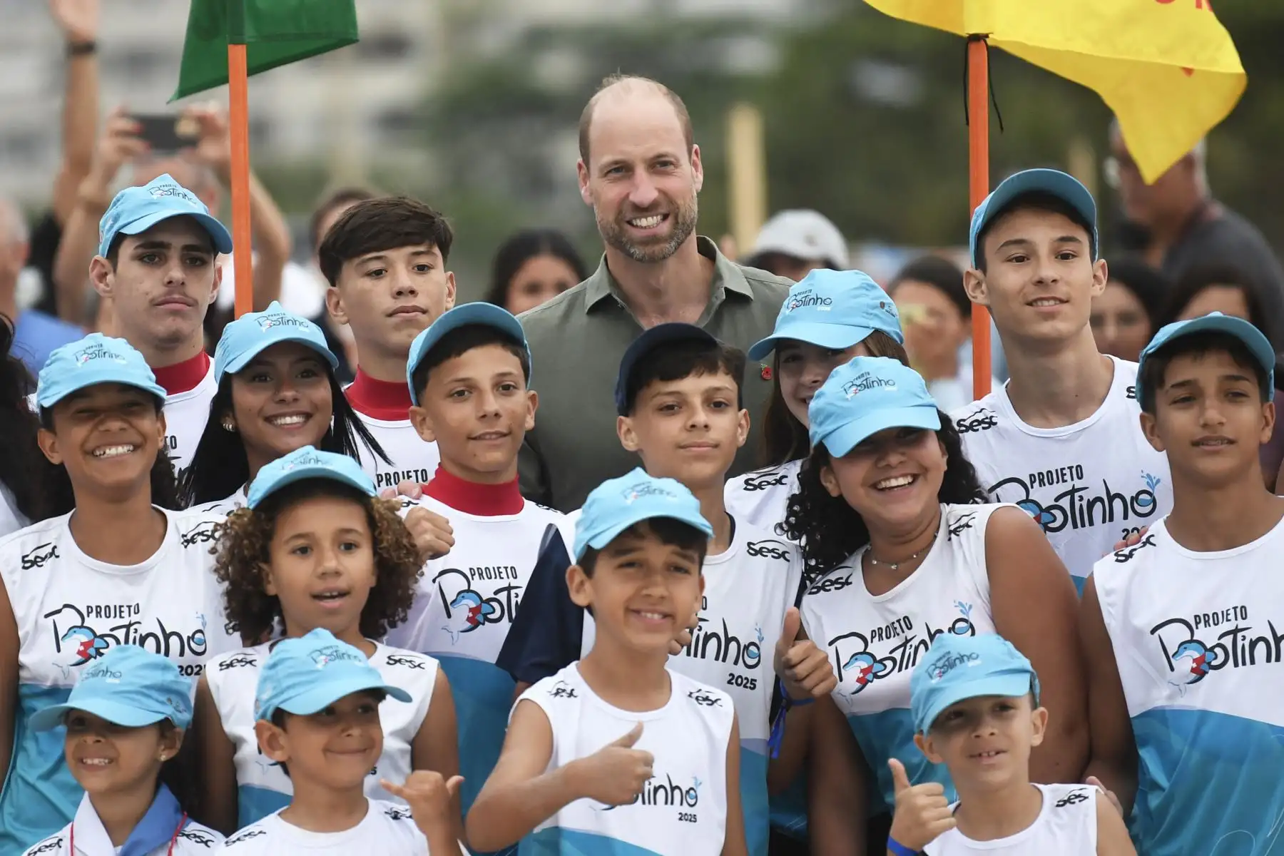 El príncipe Guillermo de Gran Bretaña, príncipe de Gales, posa para una fotografía con niños de un proyecto social durante una reunión con socorristas en la playa de Copacabana, en Río de Janeiro. AFP