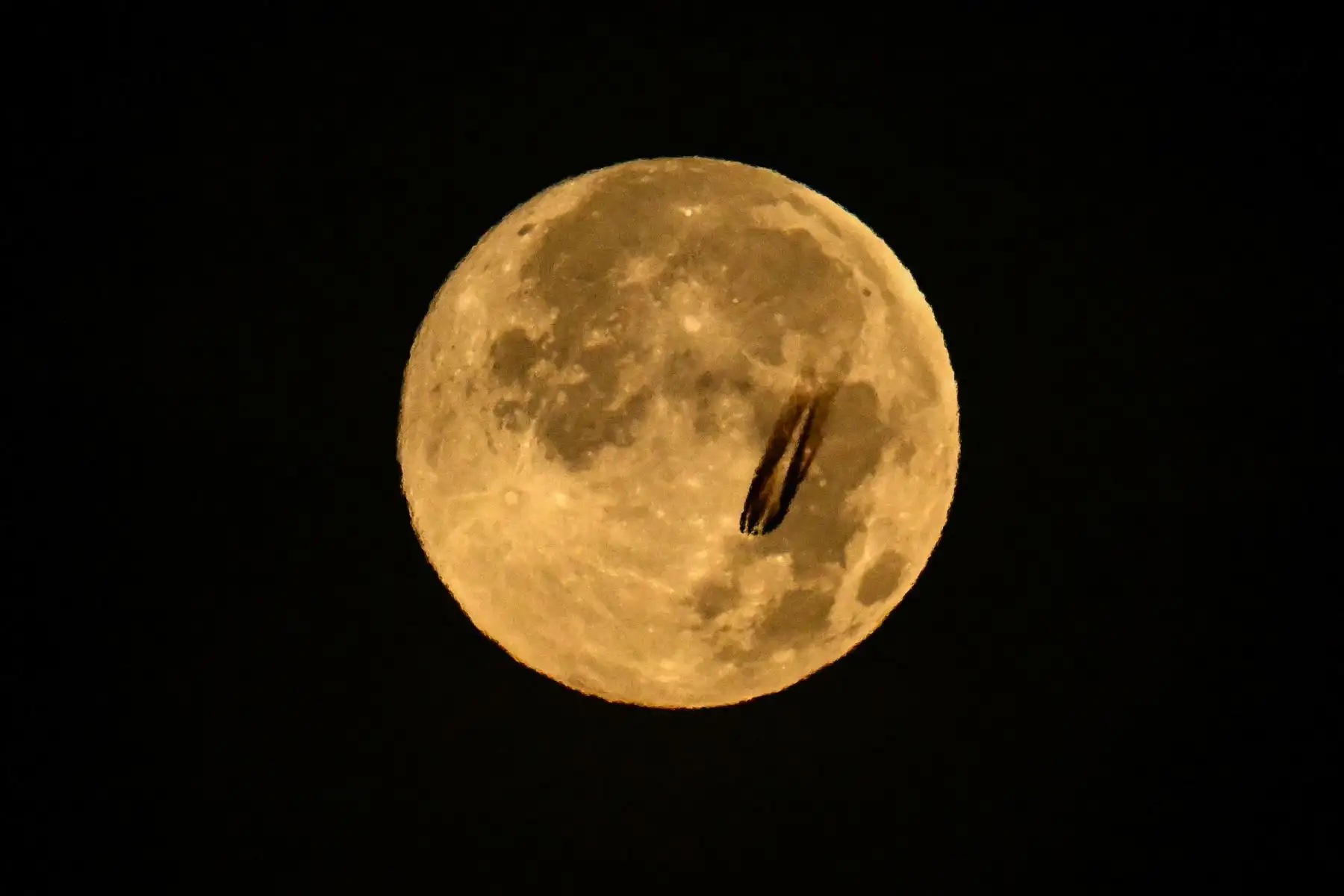 Un avión a reacción sobrevuela la luna llena de noviembre, también conocida como "Luna del Castor", sobre el distrito financiero de Fráncfort del Meno, en el oeste de Alemania. AFP
