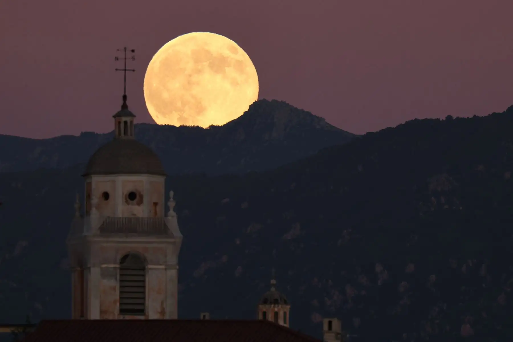 Última superluna de 2025 elevándose sobre el campanario de la catedral de Ajaccio, en la isla francesa de Córcega, en el Mediterráneo. AFP