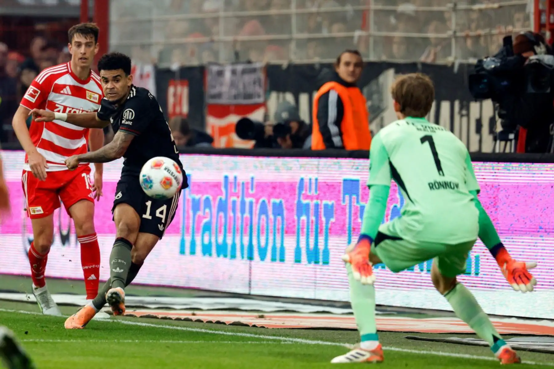 El delantero colombiano del Bayern Munich, Luis Díaz, anota el primer gol de su equipo ante el portero danés del Union Berlin, Frederik Ronnow, durante el partido de fútbol de la primera división alemana Bundesliga entre FC Union Berlin y FC Bayern Munich en Berlín el 8 de noviembre de 2025. Foto: AFP