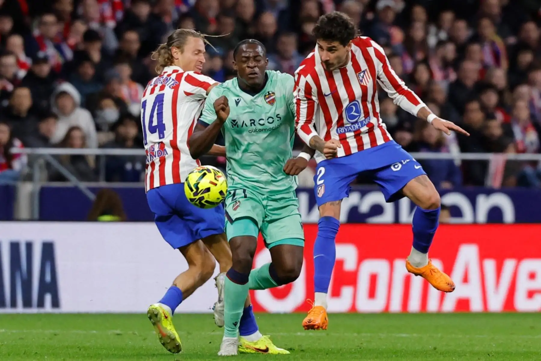 El centrocampista camerunés del Levante, Karl Etta Eyong (nº 21), disputa el balón con el centrocampista español del Atlético de Madrid, Marcos Llorente (nº 14), y el defensa uruguayo del Atlético de Madrid, José Giménez (nº 02), durante el partido de Liga entre el Club Atlético de Madrid y el Levante UD en el Estadio Metropolitano de Madrid el 8 de noviembre de 2025. (Foto de Oscar DEL POZO / AFP)