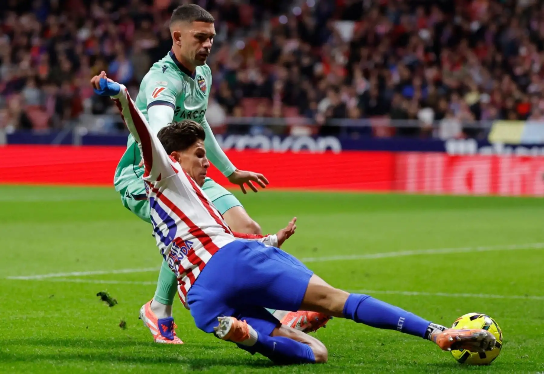 El delantero argentino del Atlético de Madrid, Giuliano Simeone (nº 20), disputa el balón con el defensa español del Levante, Adrián De La Fuente (nº 4), durante el partido de Liga entre el Club Atlético de Madrid y el Levante UD en el Estadio Metropolitano de Madrid el 8 de noviembre de 2025. (Foto de Oscar DEL POZO / AFP)