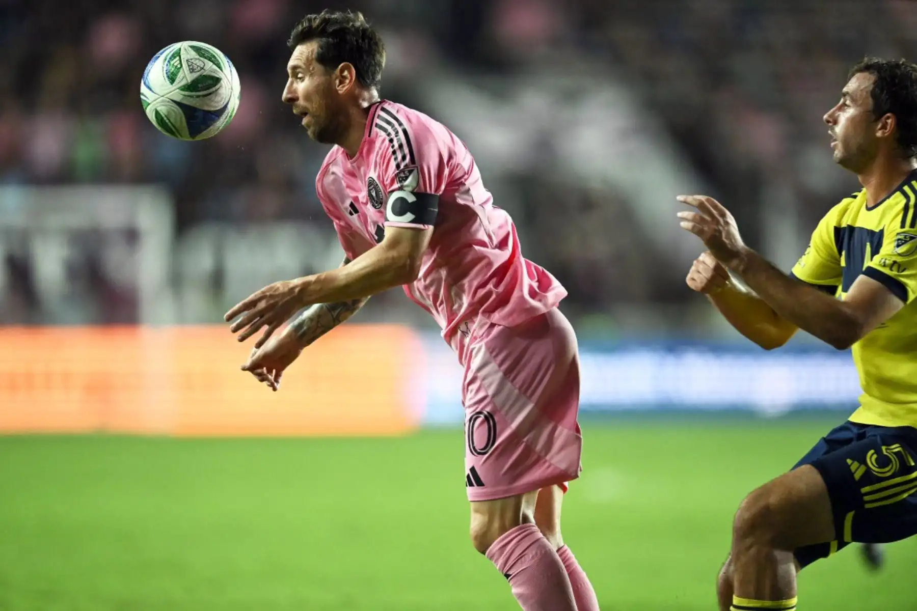 El delantero argentino del Inter Miami, Lionel Messi (izq.), número 10, es empujado por detrás por el defensor estadounidense del Nashville SC, Jack Maher (número 5), durante el partido de playoffs de la Major League Soccer (MLS) entre el Inter Miami y el Nashville SC en el Chase Stadium de Fort Lauderdale, Florida, el 8 de noviembre de 2025. (Foto de Chandan Khanna / AFP)