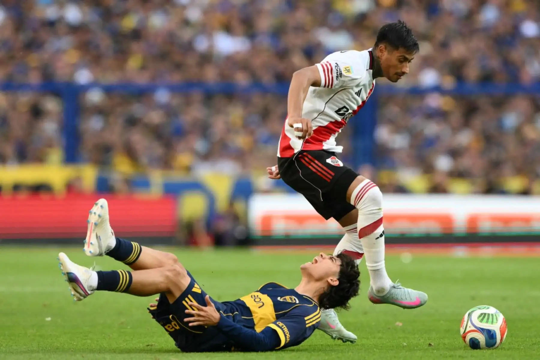 El delantero #07 de Boca Juniors Exequiel Zeballos (L) hace muecas de dolor junto al delantero #07 de River Plate, Maximiliano Salas, durante el partido del Torneo de Clausura de la Liga Argentina de Fútbol Profesional 2025 entre Boca Juniors y River Plate en el Estadio La Bombonera de Buenos Aires el 9 de noviembre de 2025. (Foto de Luis ROBAYO / AFP)