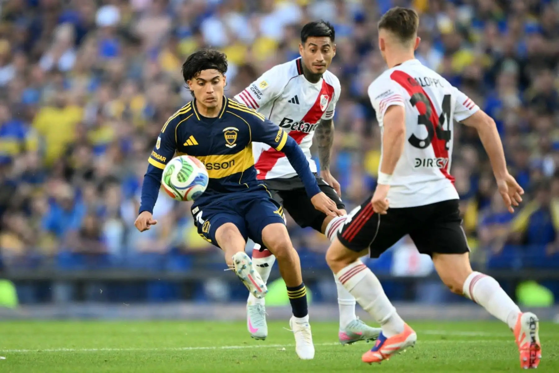 El delantero #07 del Boca Juniors, Exequiel Zeballos (ier), lucha por el balón con el centrocampista #34 de River Plate, Giuliano Galoppo, y el centrocampista #05 Juan Portillo, durante el partido del Torneo de Clausura de la Liga Argentina de Fútbol Profesional 2025 entre Boca Juniors y River Plate en el Estadio La Bombonera de Buenos Aires el 9 de noviembre de 2025. (Foto de Luis ROBAYO / AFP)
