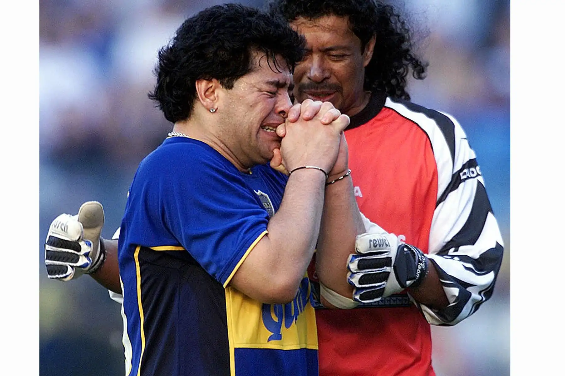 El portero colombiano René Higuita consuela al exastro del fútbol argentino Diego Maradona, visiblemente emocionado, durante un evento en su honor en el estadio "La Bombonera" del club Boca Juniors el 10 de noviembre de 2001 en Buenos Aires. Foto: AFP
