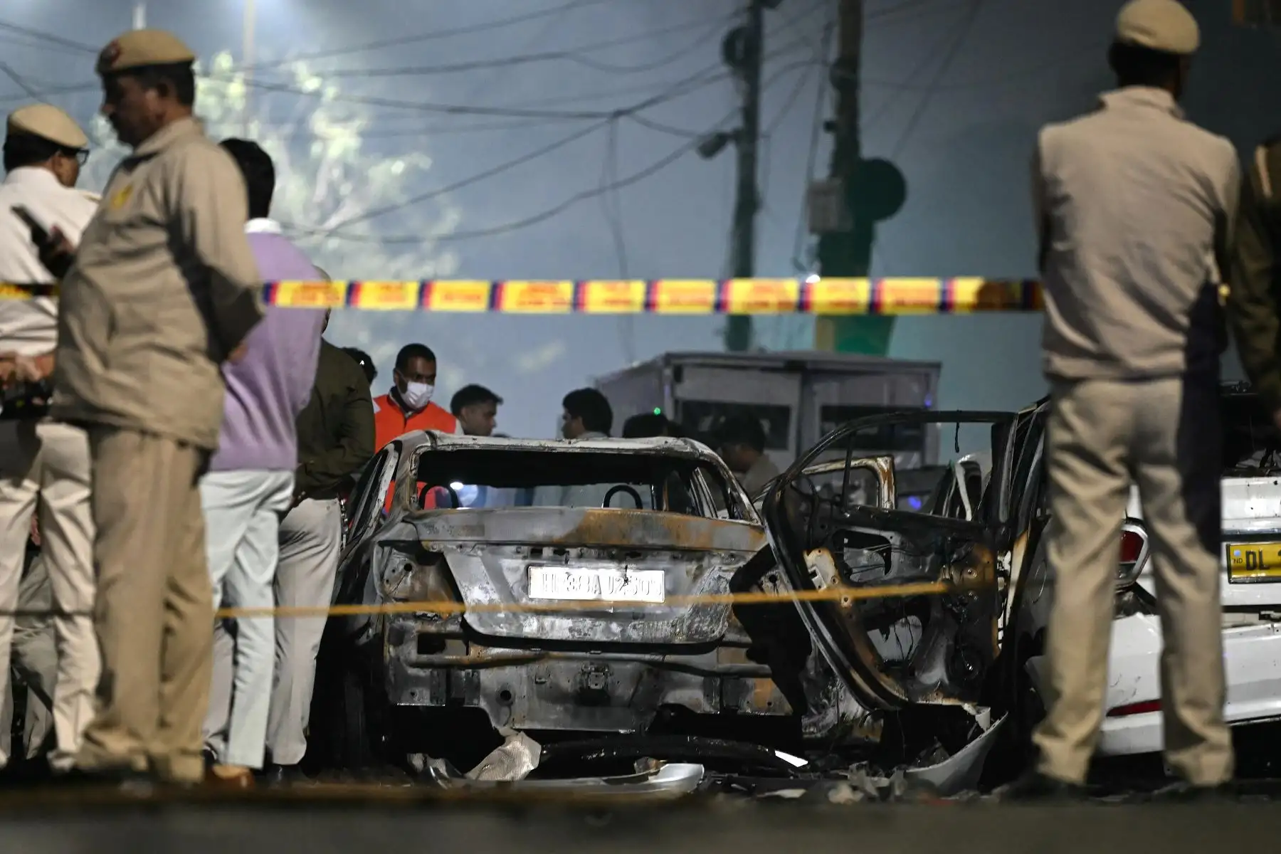 Personal de seguridad permanece junto a vehículos carbonizados en el lugar de la explosión ocurrida cerca del Fuerte Rojo en el casco antiguo de Delhi, La India, el 10 de noviembre de 2025. Foto: AFP