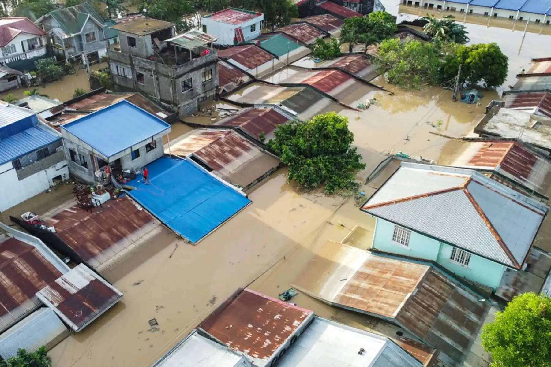 Residentes de la ciudad de Ilagan, provincia de Isabela, al norte de Manila, se encuentran en el techo de sus casas inundadas mientras las intensas lluvias provocadas por el supertifón Fung-wong continúan anegando viviendas. AFP