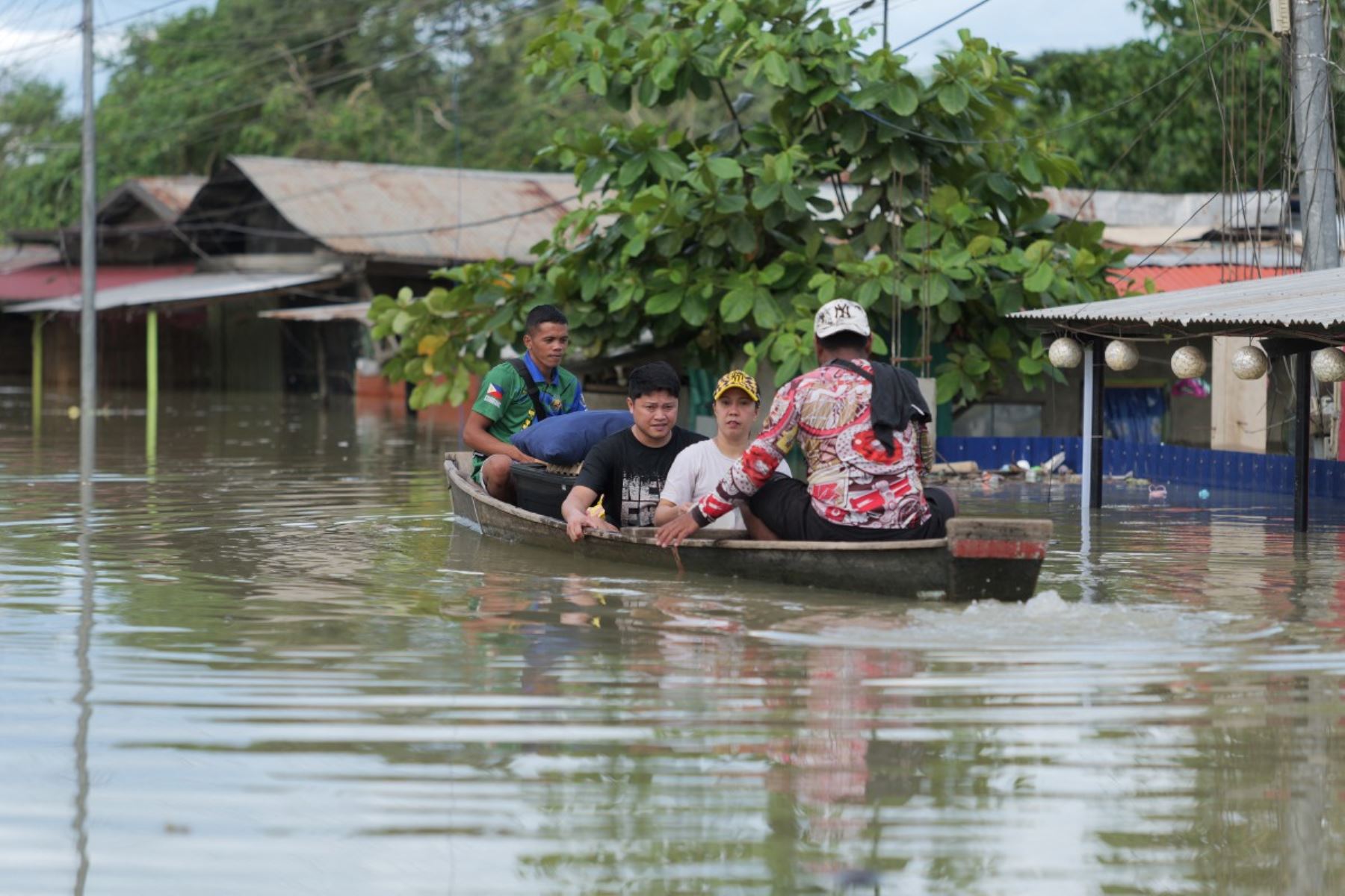 Residentes en una barca de madera evacuan sus casas inundadas en una aldea de la ciudad de Tuguegarao, provincia de Cagayán, al norte de Manila. AFP